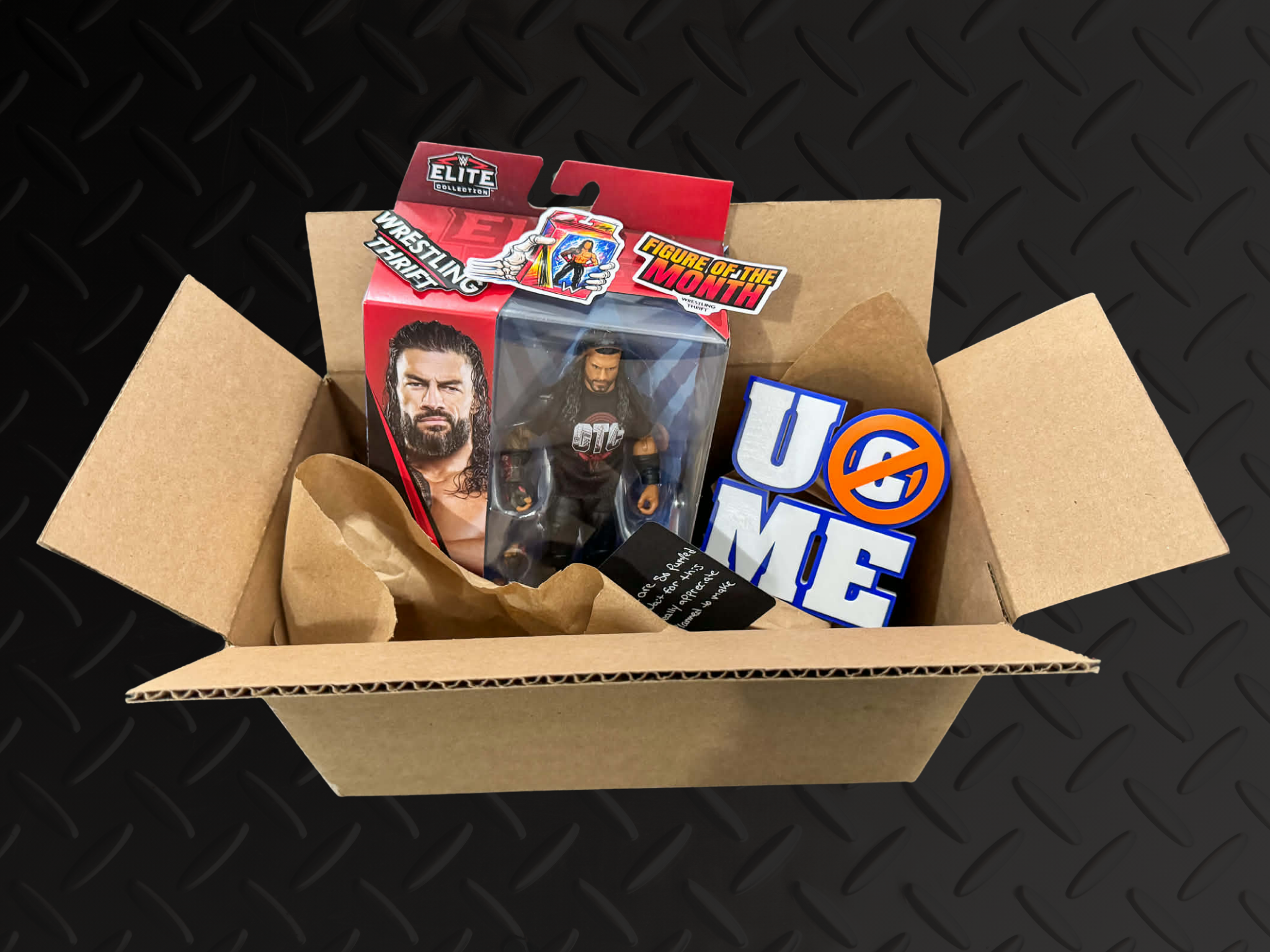 Open cardboard box containing wrestling action figures, including a figure of a male wrestler with long hair and a beard, along with wrestling-themed stickers and signs.