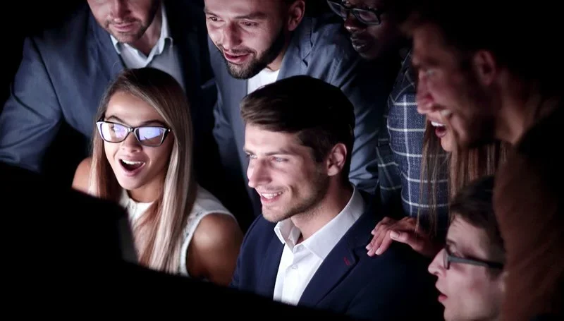 A group of executives smiling and collaborating in a modern office, representing leadership in digital transformation.