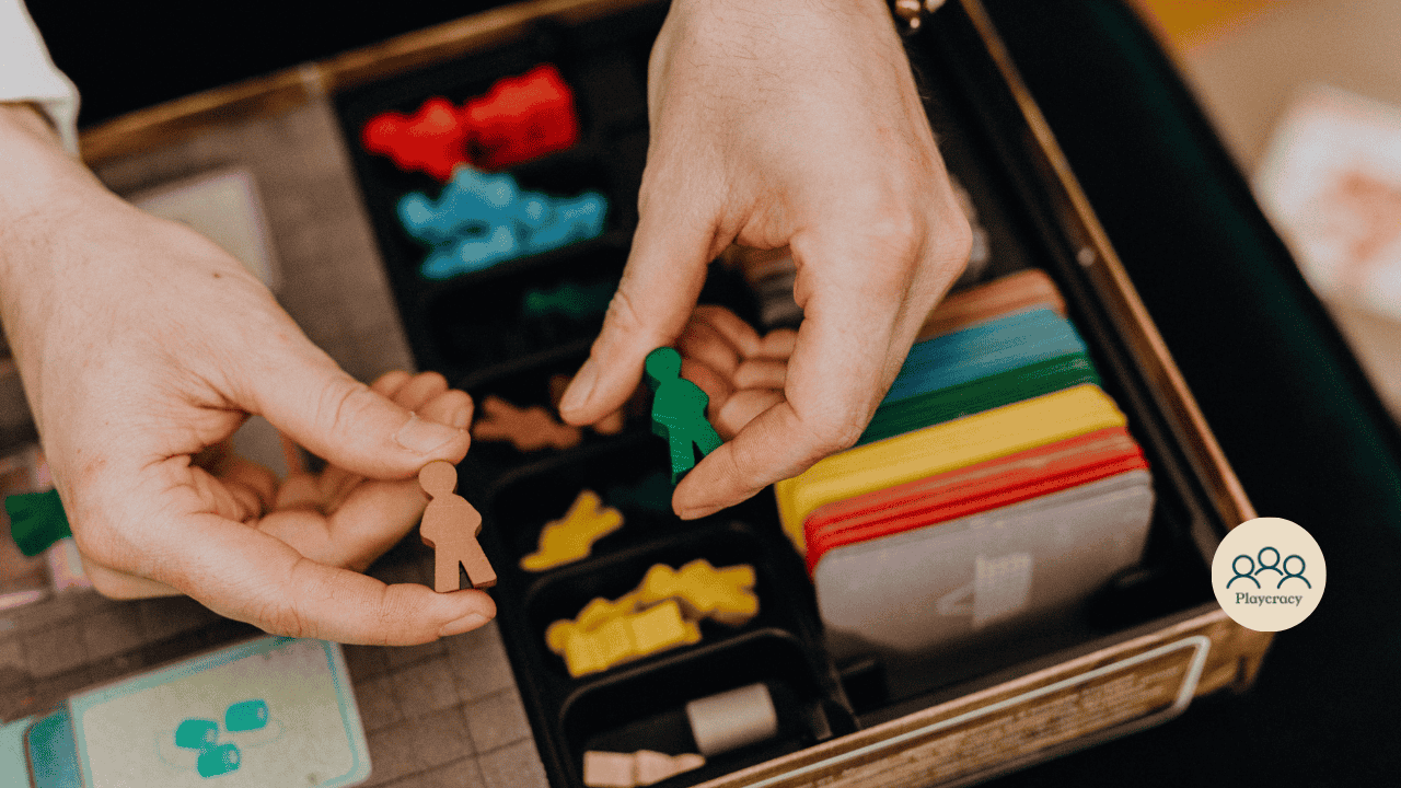 Meeples placed in a game board box, one brown, one green