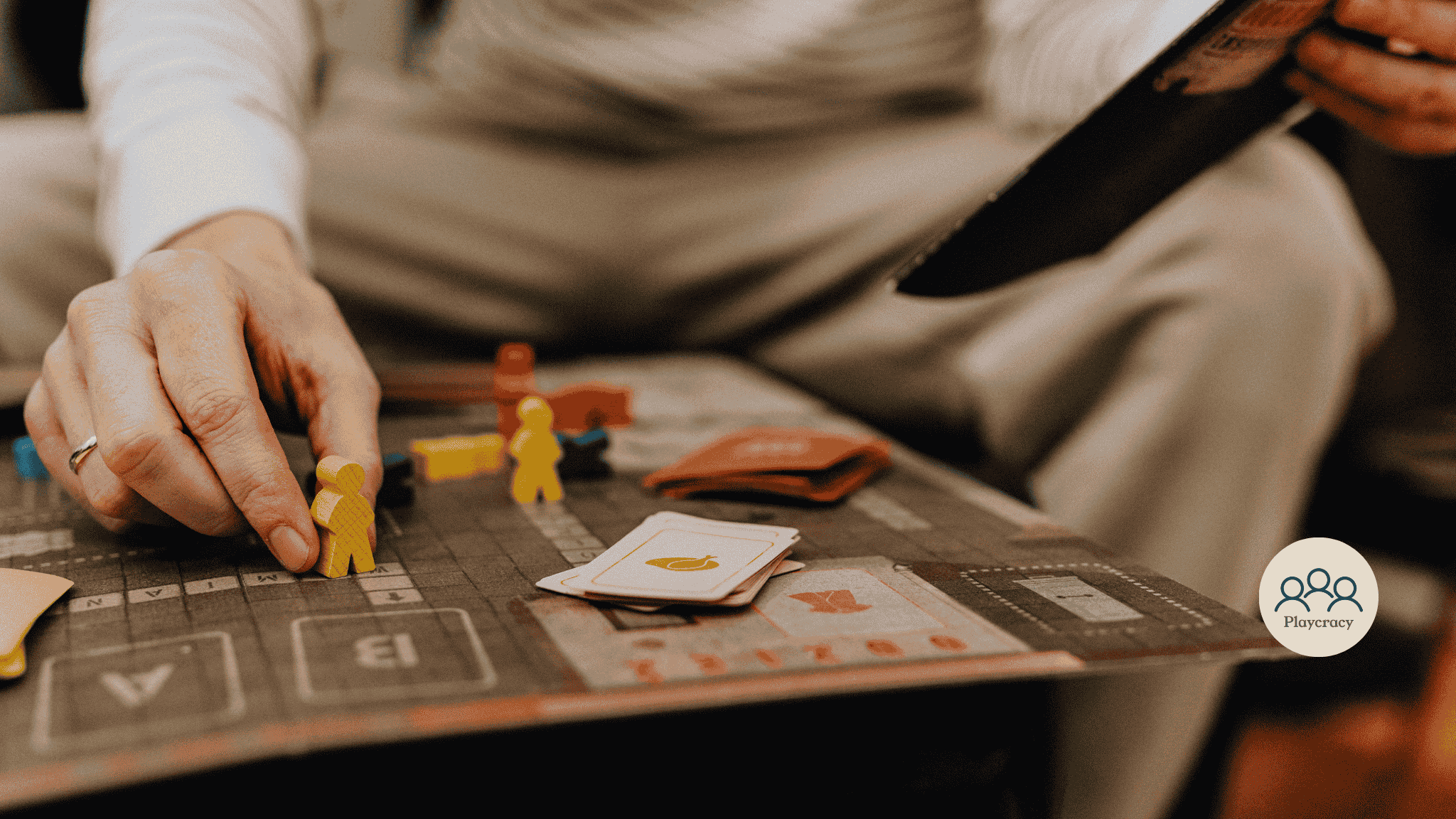 A hand is placing a meeple on a board