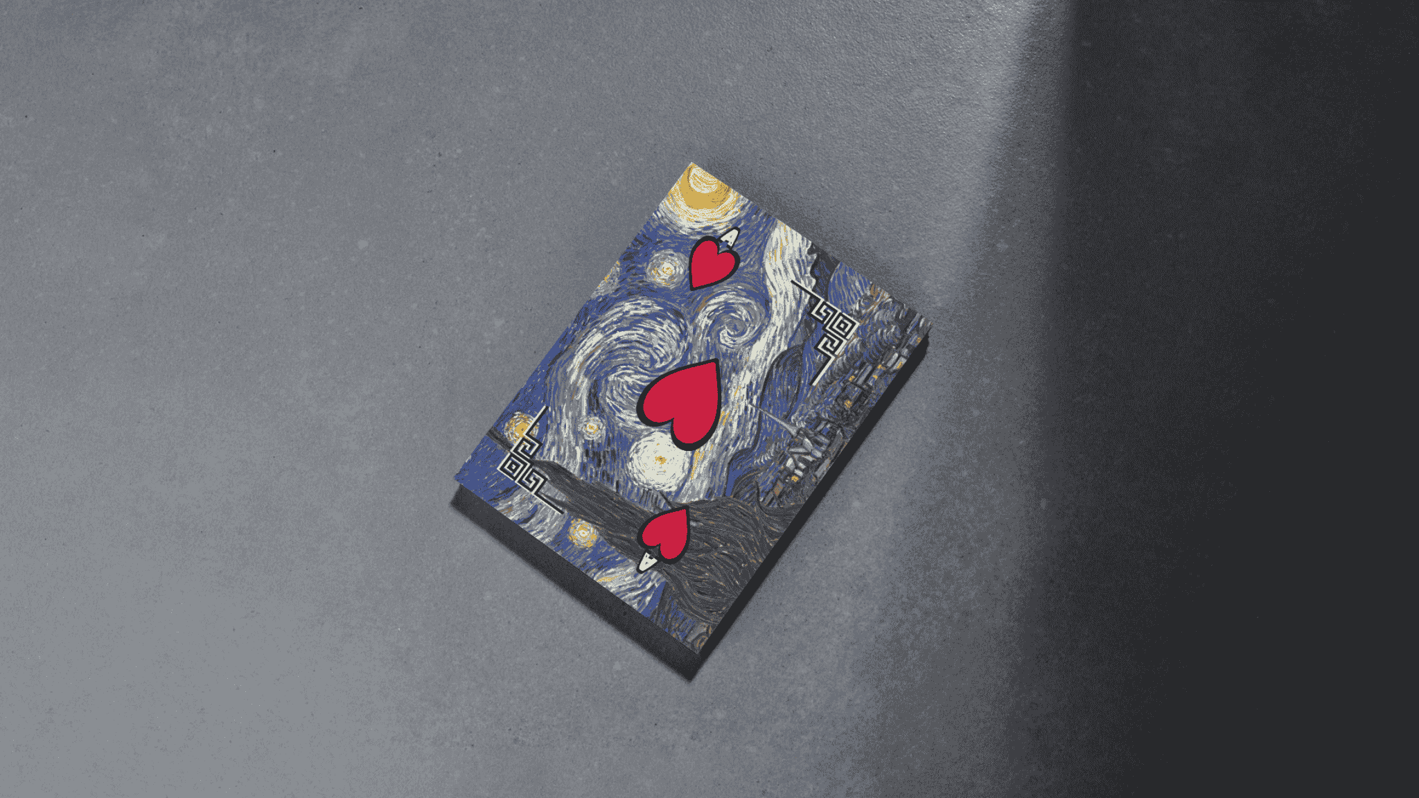 A playing card with artwork inspired by Vincent van Gogh's 'Starry Night', featuring three red hearts on the card, placed on a gradient gray surface.