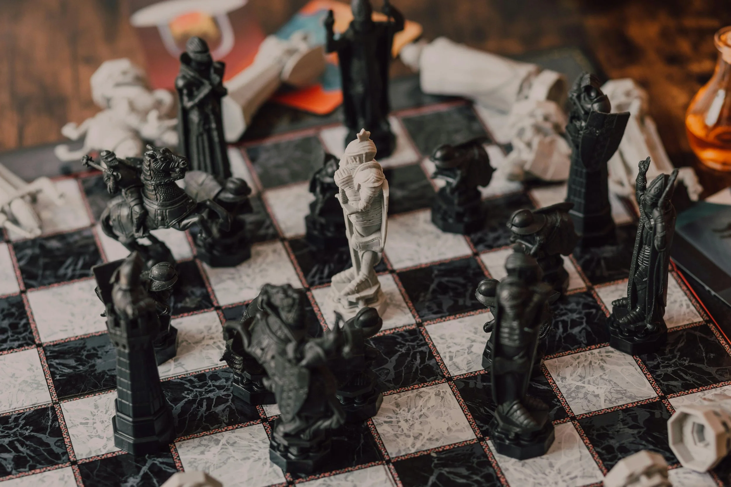 A chessboard with black and white chess pieces, including a white king at the center, set up on a marble-patterned board.