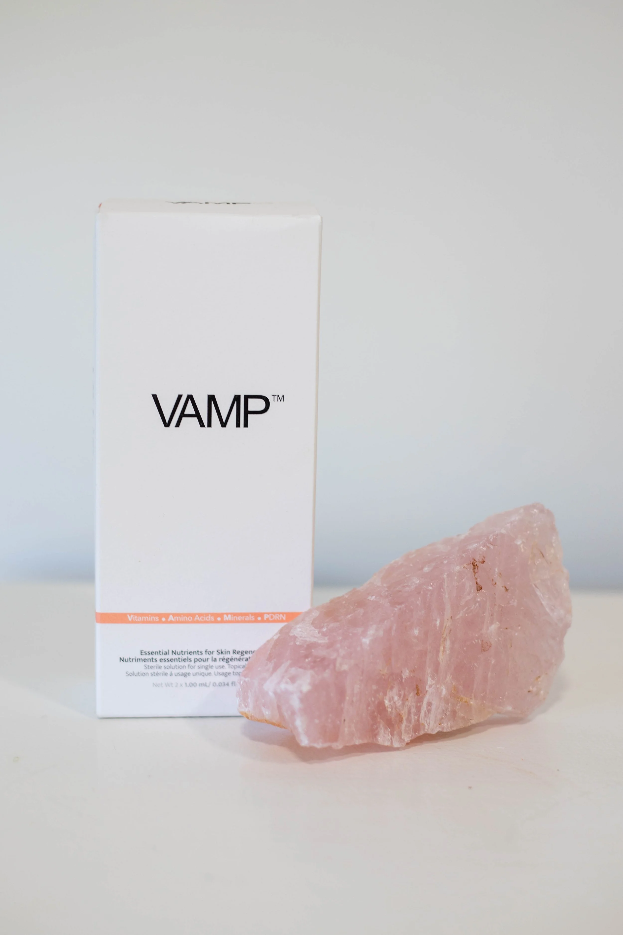 A white box labeled 'VAMP' with a pink crystal rock beside it on a plain background.
