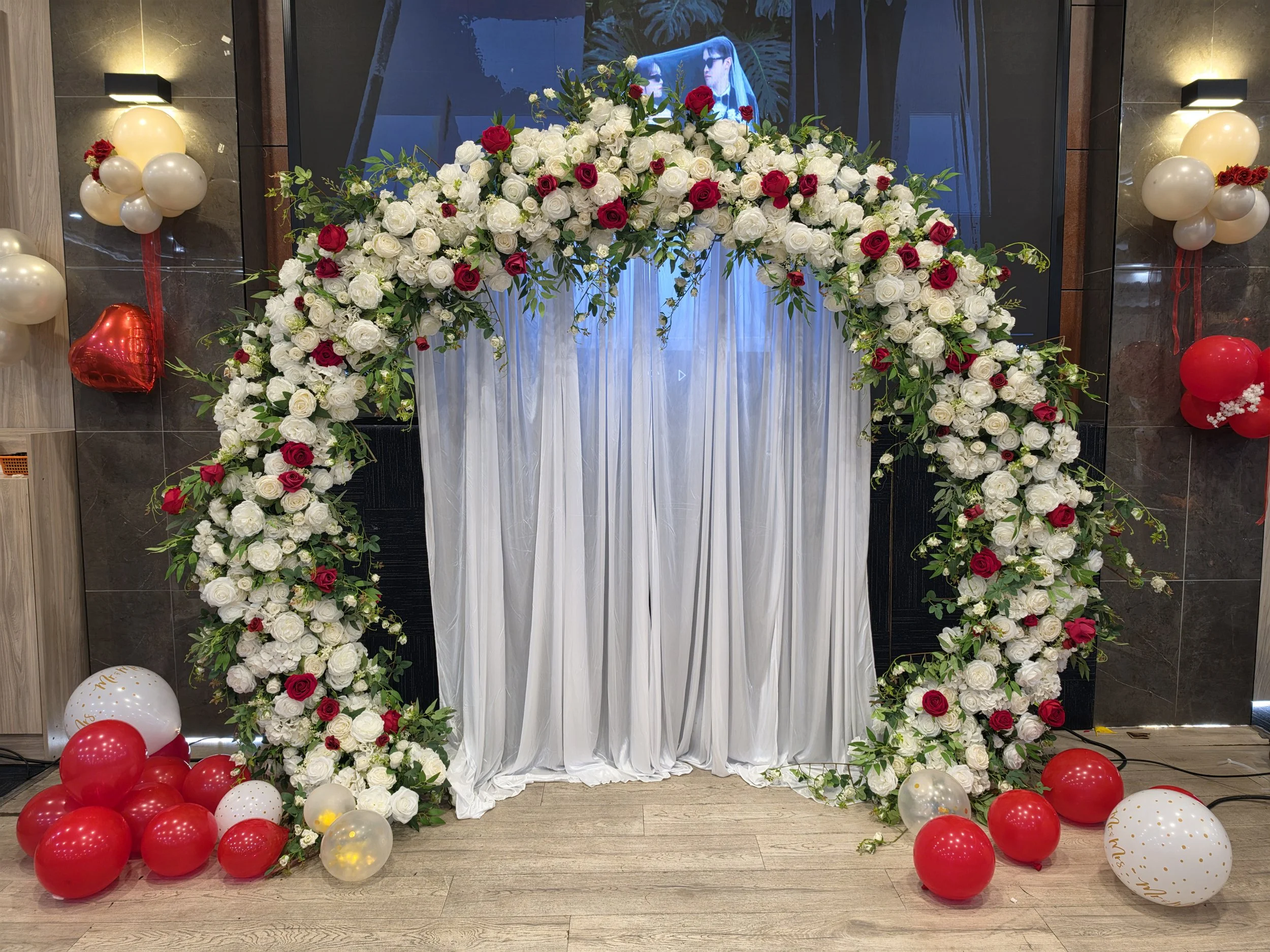 Elegant round wedding arch with white drapes and floral arrangements
