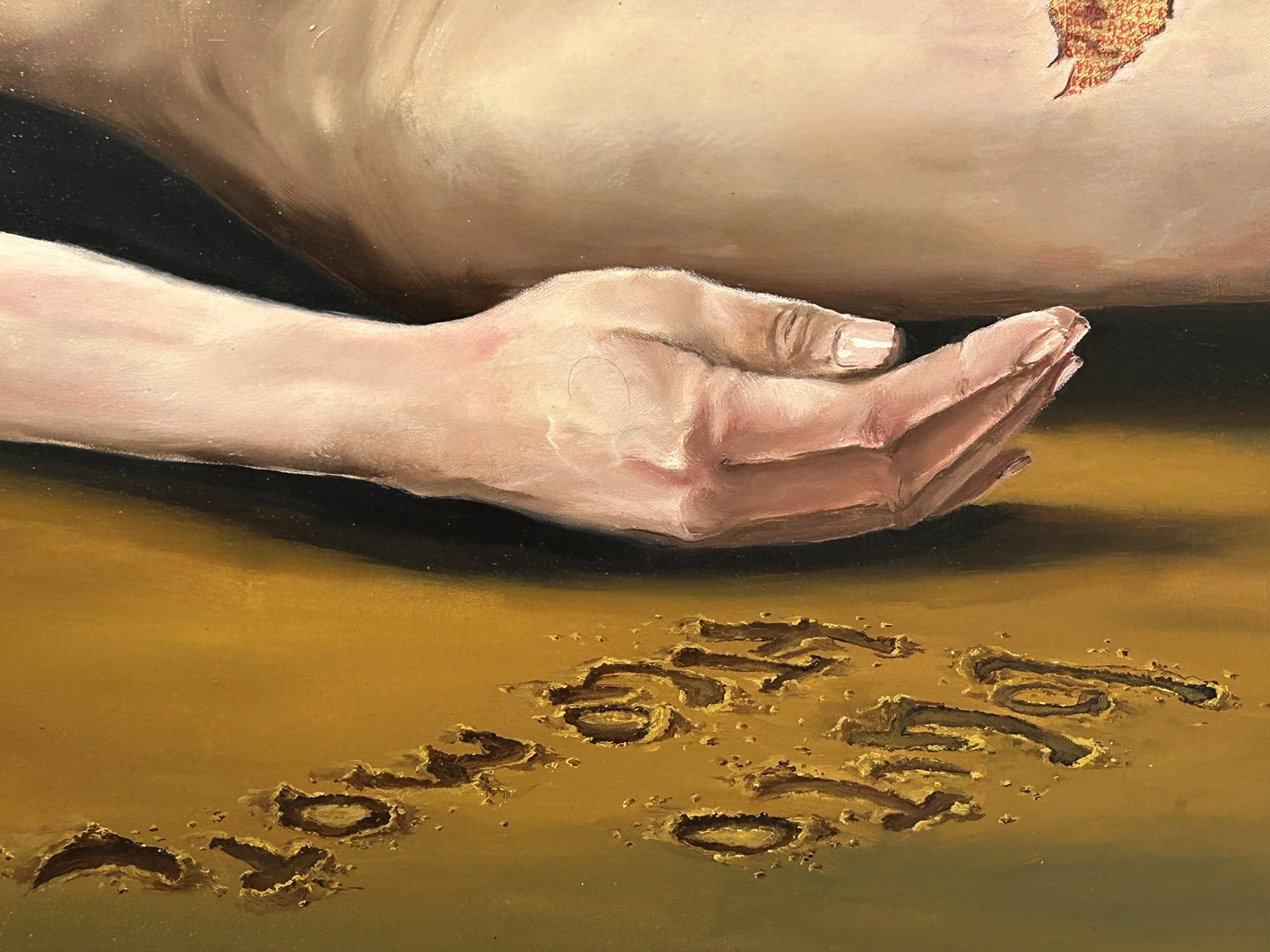 Une main humaine posée à plat sur une surface jaune, avec des lettres gravées dans la surface en dessous.