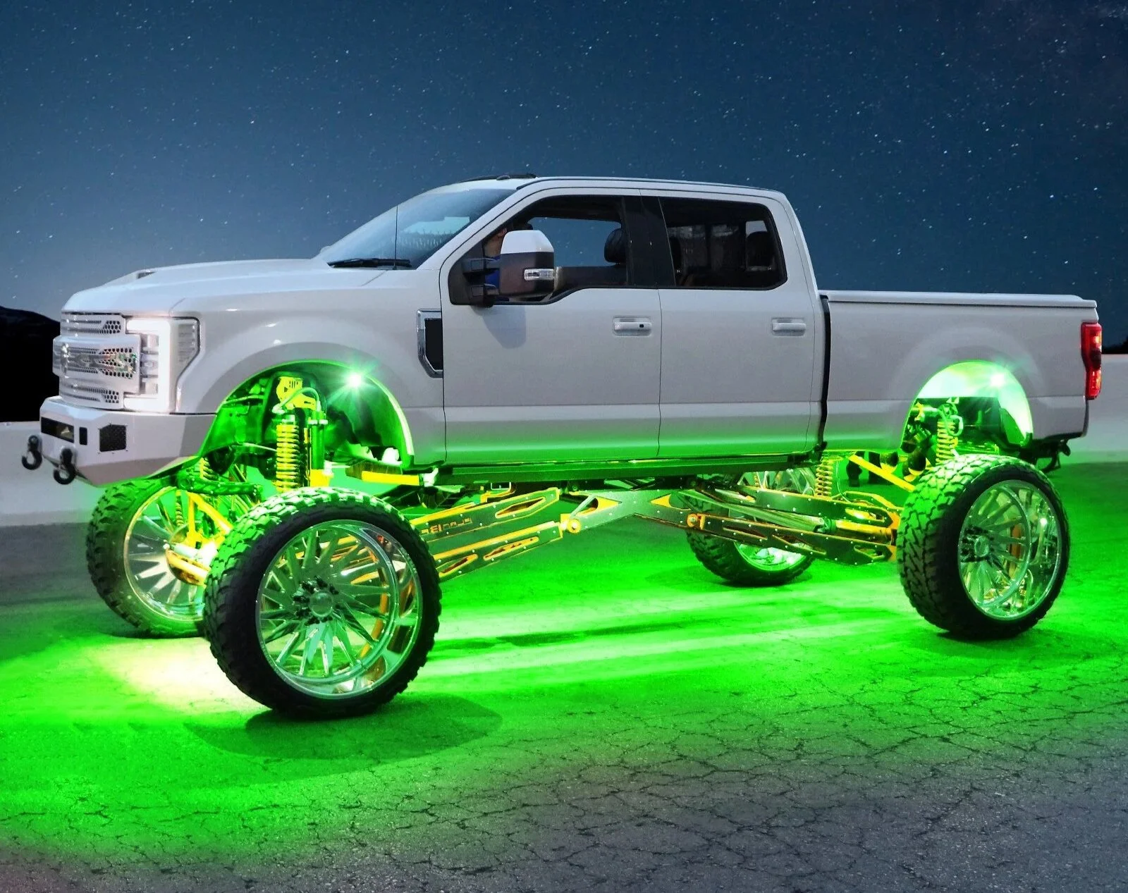 A white pickup truck with glowing green undercarriage and large custom wheels, set against a night sky background.