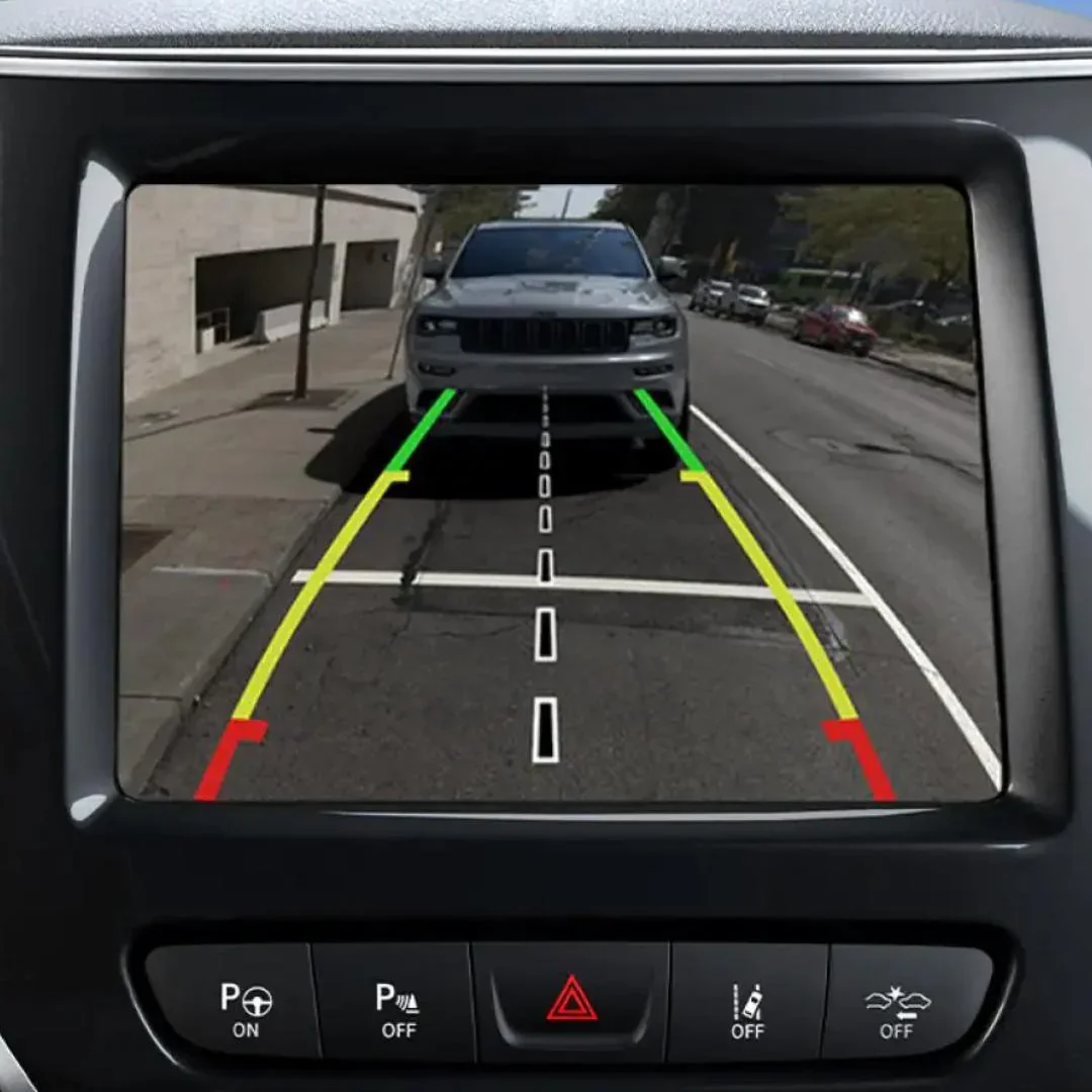 Car's rearview camera display showing parking guidelines with a silver vehicle directly behind, in a parking space on the street.