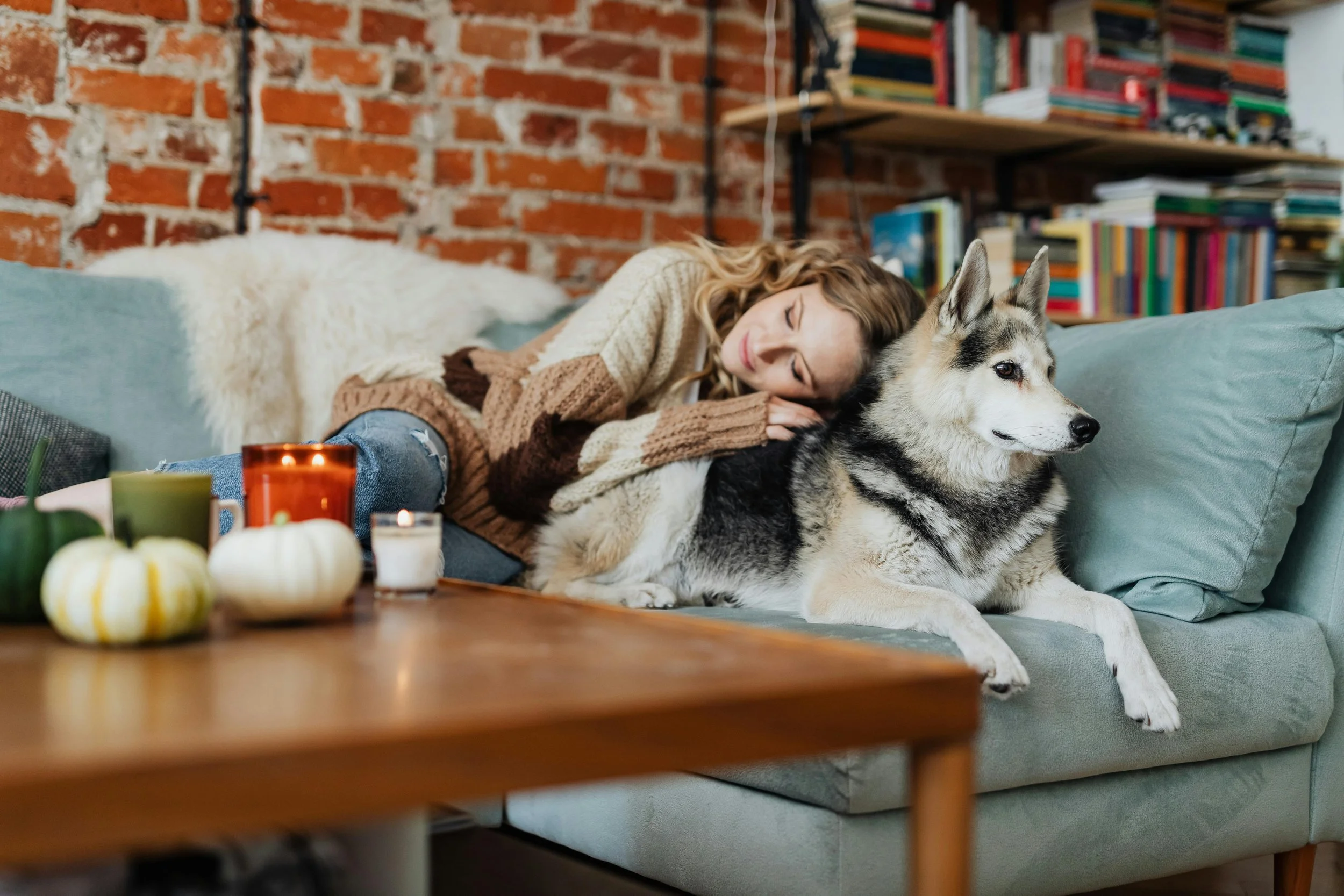 a woman laying on a couch with a dog