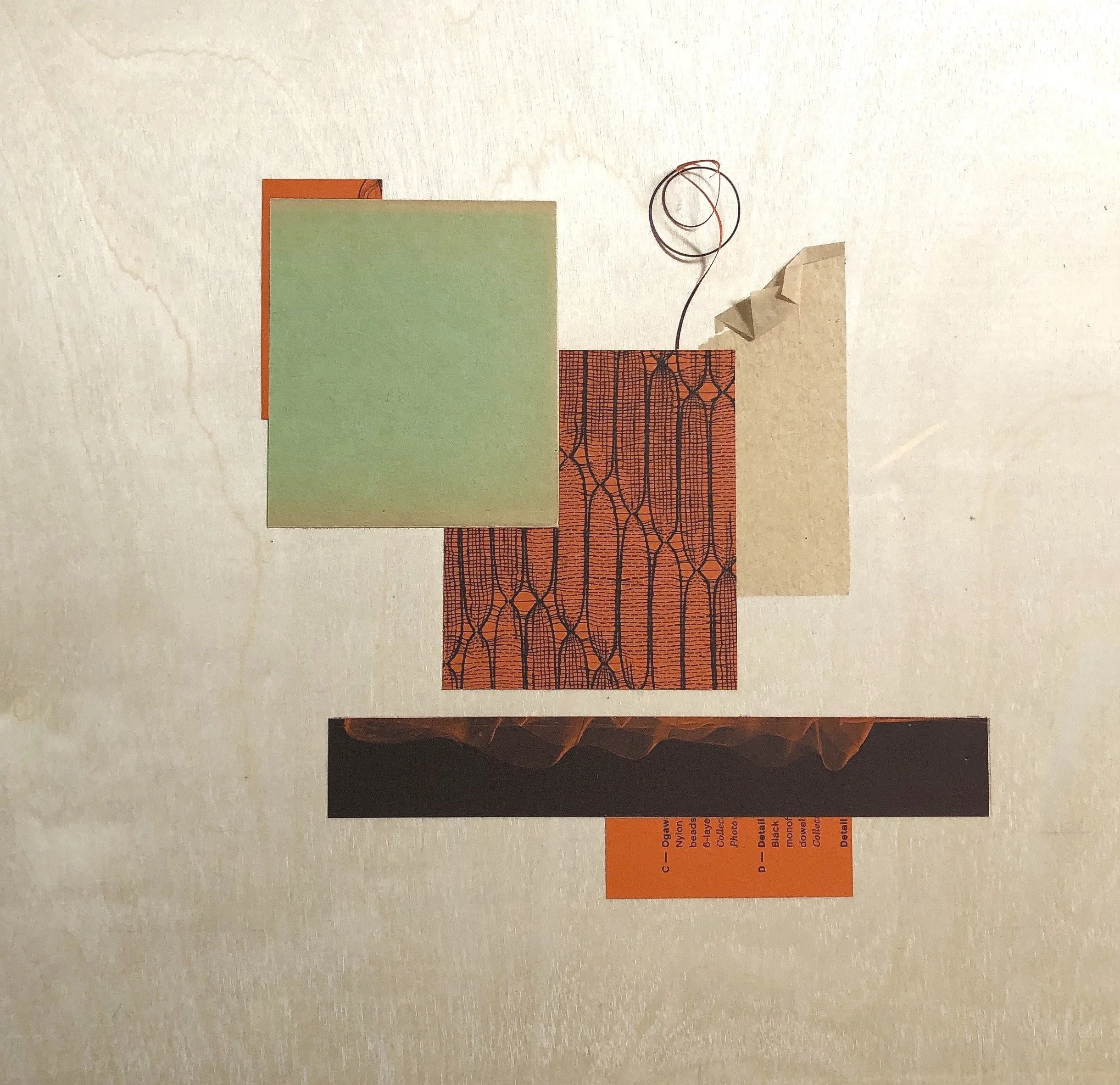 A collage of various cut-out papers on a light-colored surface, including solid colors, patterns, and a small wire spiral.