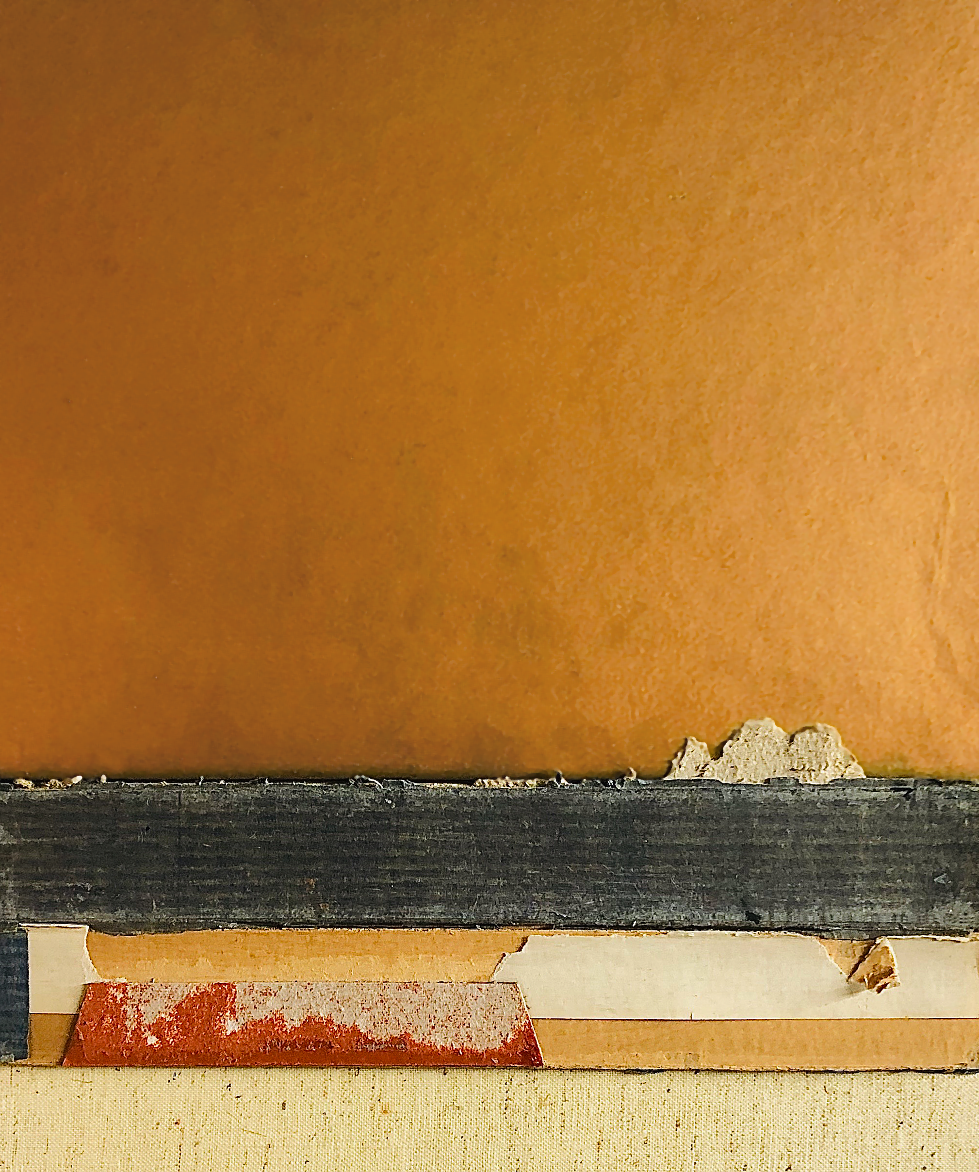 Close-up of a wooden surface with dust or debris on it, with some peeling paint or material along the edges.