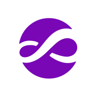 Smiling woman with dark hair wearing a blue top, outdoors with green plants in the background.