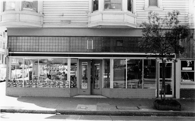 An ornate building with a barbershop on the ground floor and residential rooms above. The barbershop has a large window display, a door with a "Closed" sign, and a sign reading "Diane's Barber Shop".