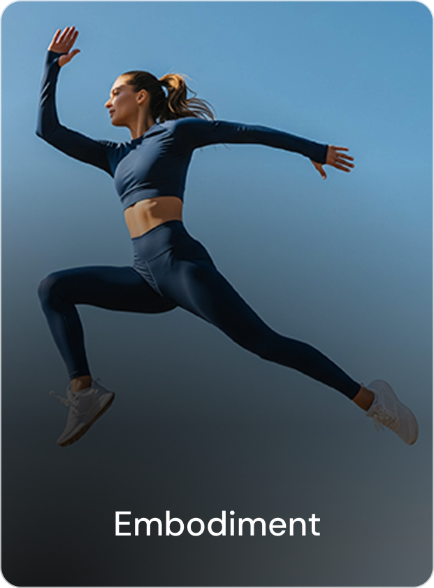 A person standing on a wooden dock looking at a calm lake surrounded by snow-covered mountains, with their reflection visible in the water.