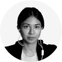 Black and white portrait of a woman with long dark hair wearing a jacket and earbuds, against a plain background.