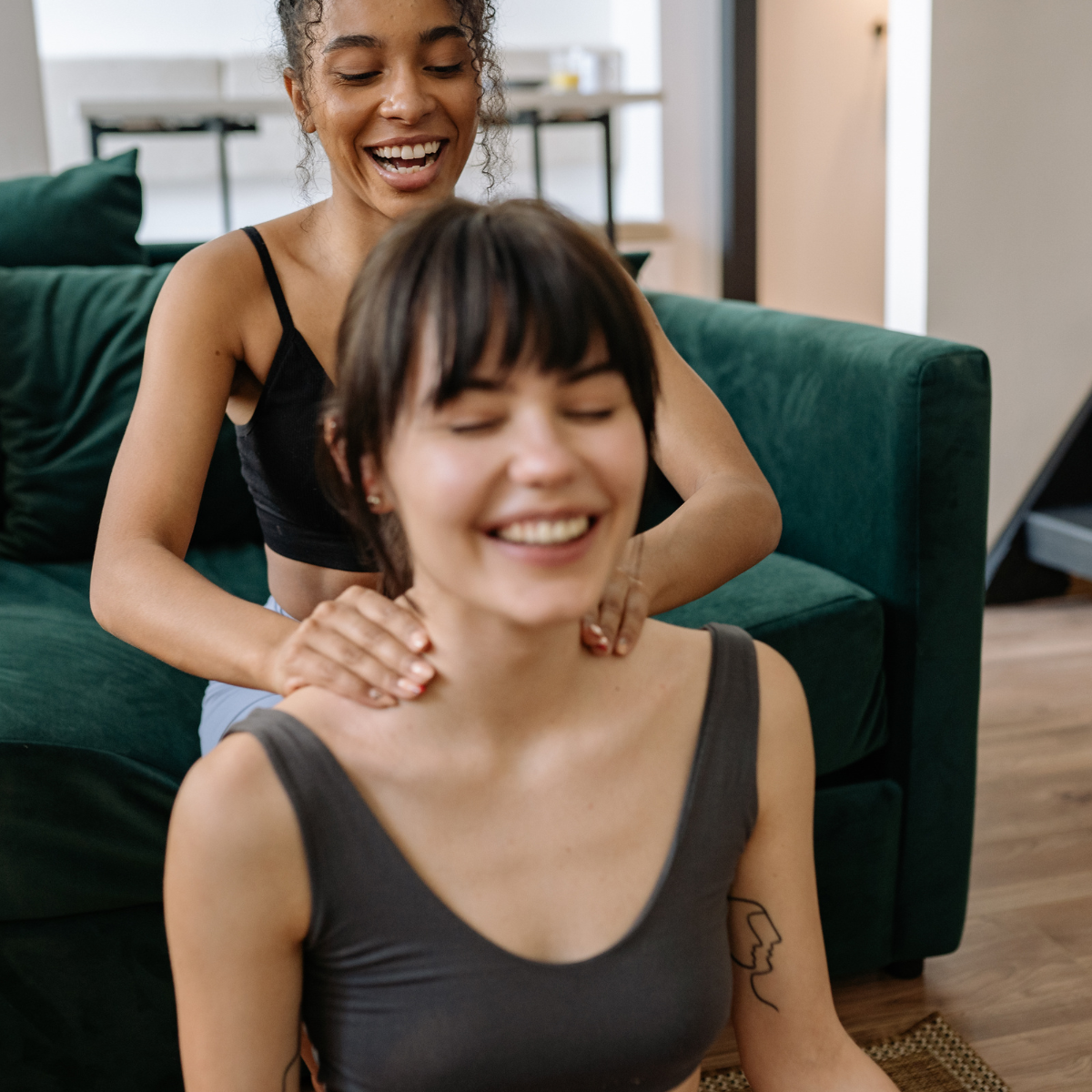 Two women laughing together in a relaxed, joyful moment, representing the genuine connection that becomes possible when ADHD women move from people pleasing toward authentic relationship.