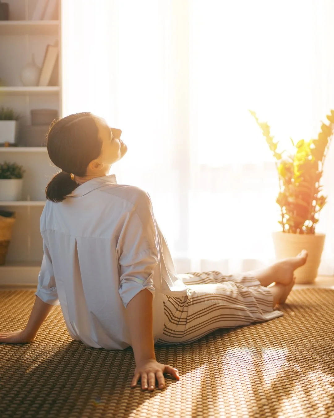 Exhausted parent practicing breathing exercises on floor for post-COVID burnout recovery and nervous system regulation