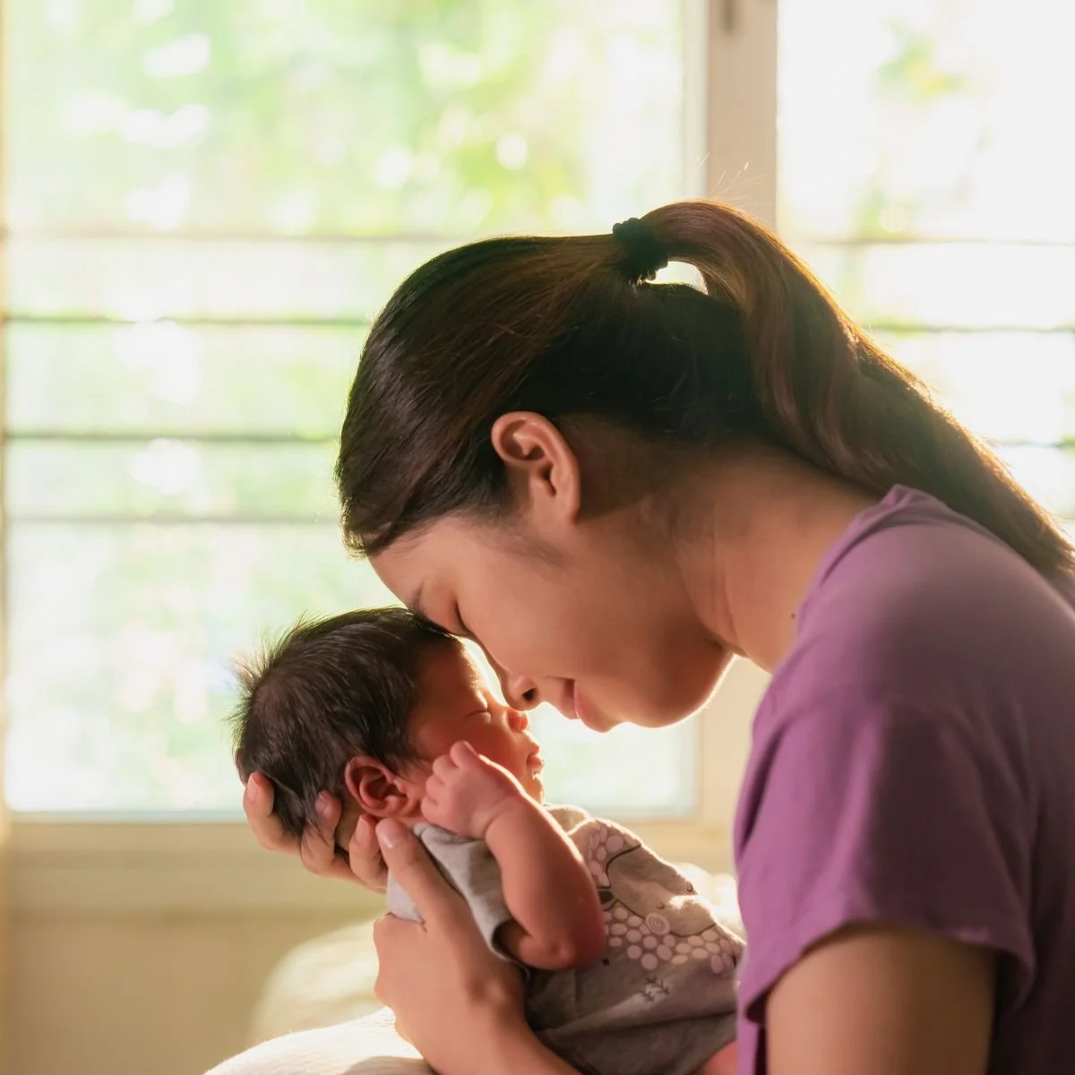 calm but exhausted and overwhelmed postpartum mom with baby