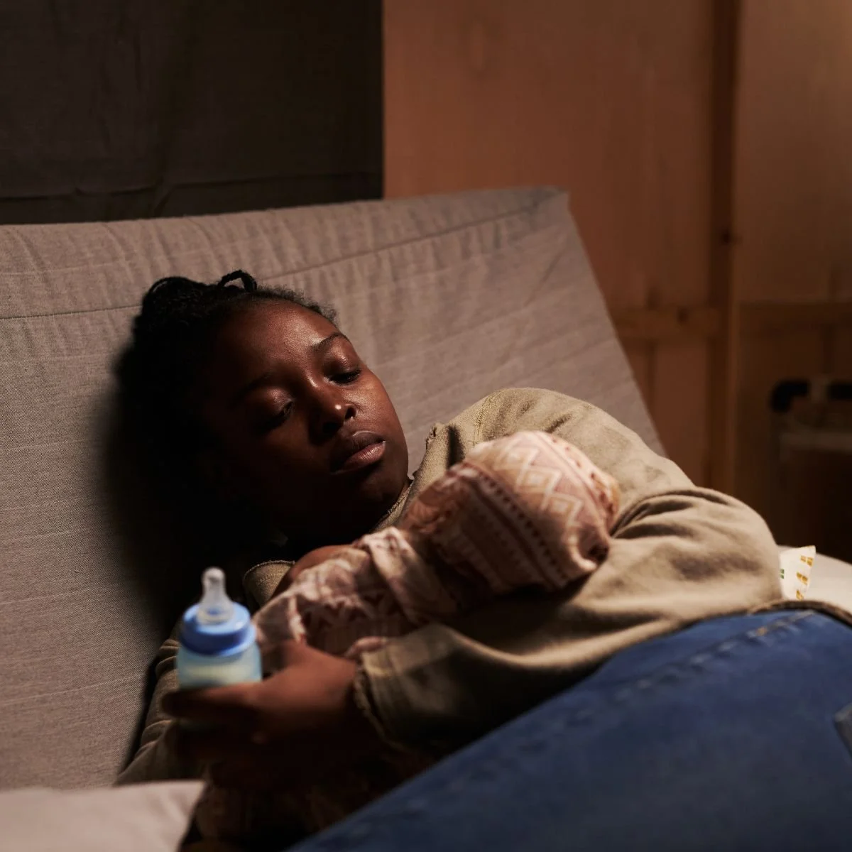 Exhausted Overwhelmed mother sitting alone showing postpartum exhaustion and mental health struggle with perfectionism