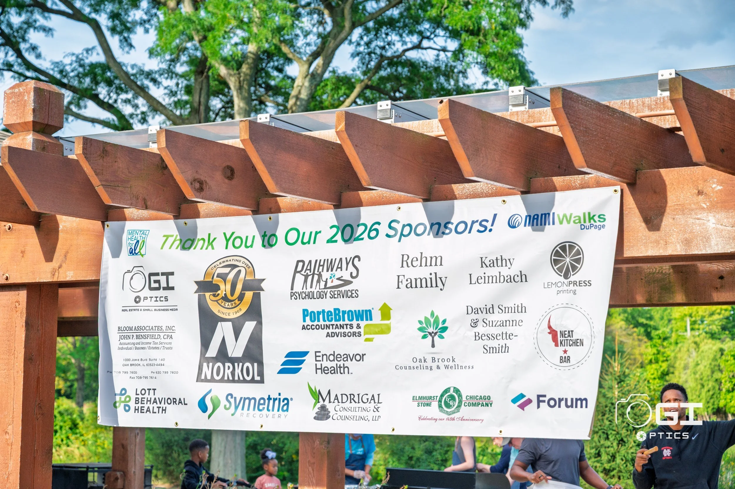 NAMIWalks DuPage 2026 sponsor banner at St. James Farm, including Ogi Optics