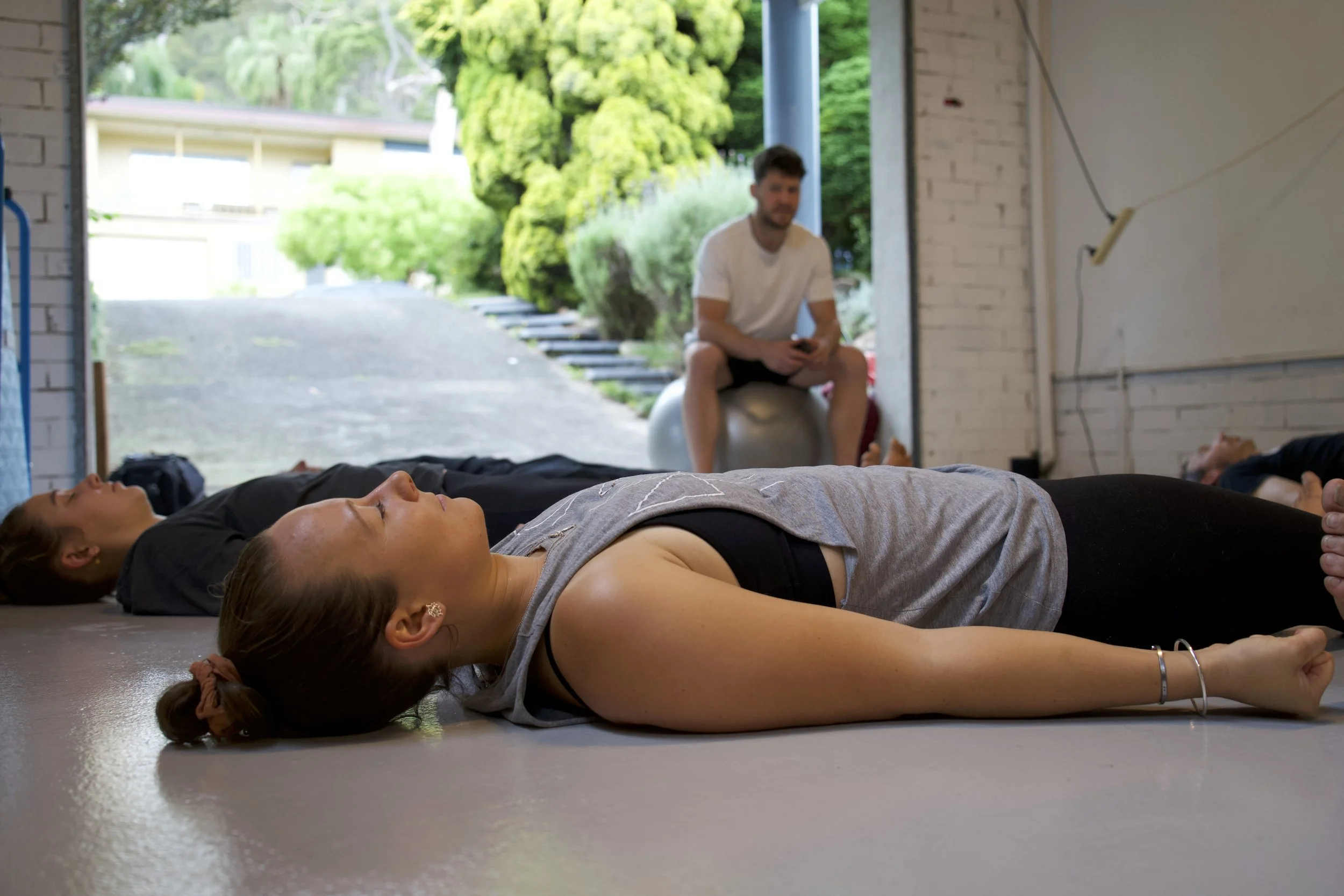 Group movement and rest session in a studio, integrating practice with recovery and reflection.