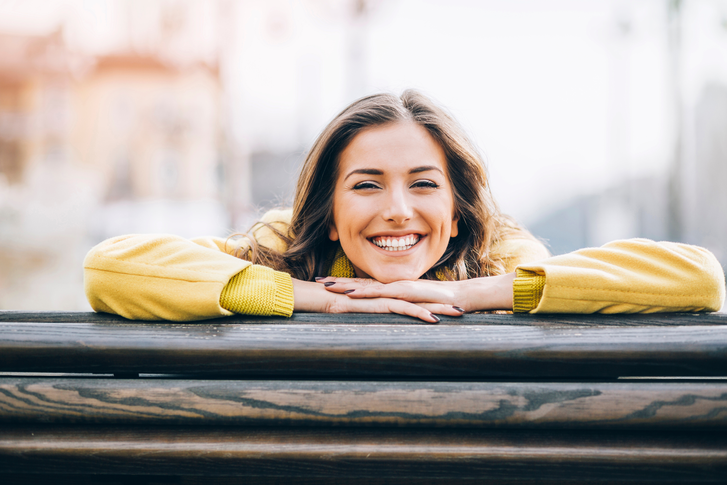 Person writing in a notebook with a pen, with another person sitting nearby.