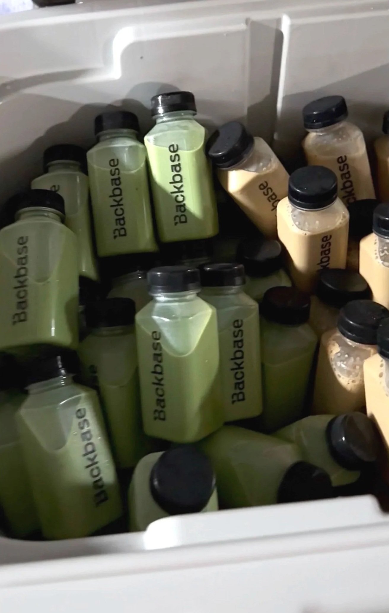 Multiple bottles of Backdrop cleaning solution stored inside a freezer or cooler.