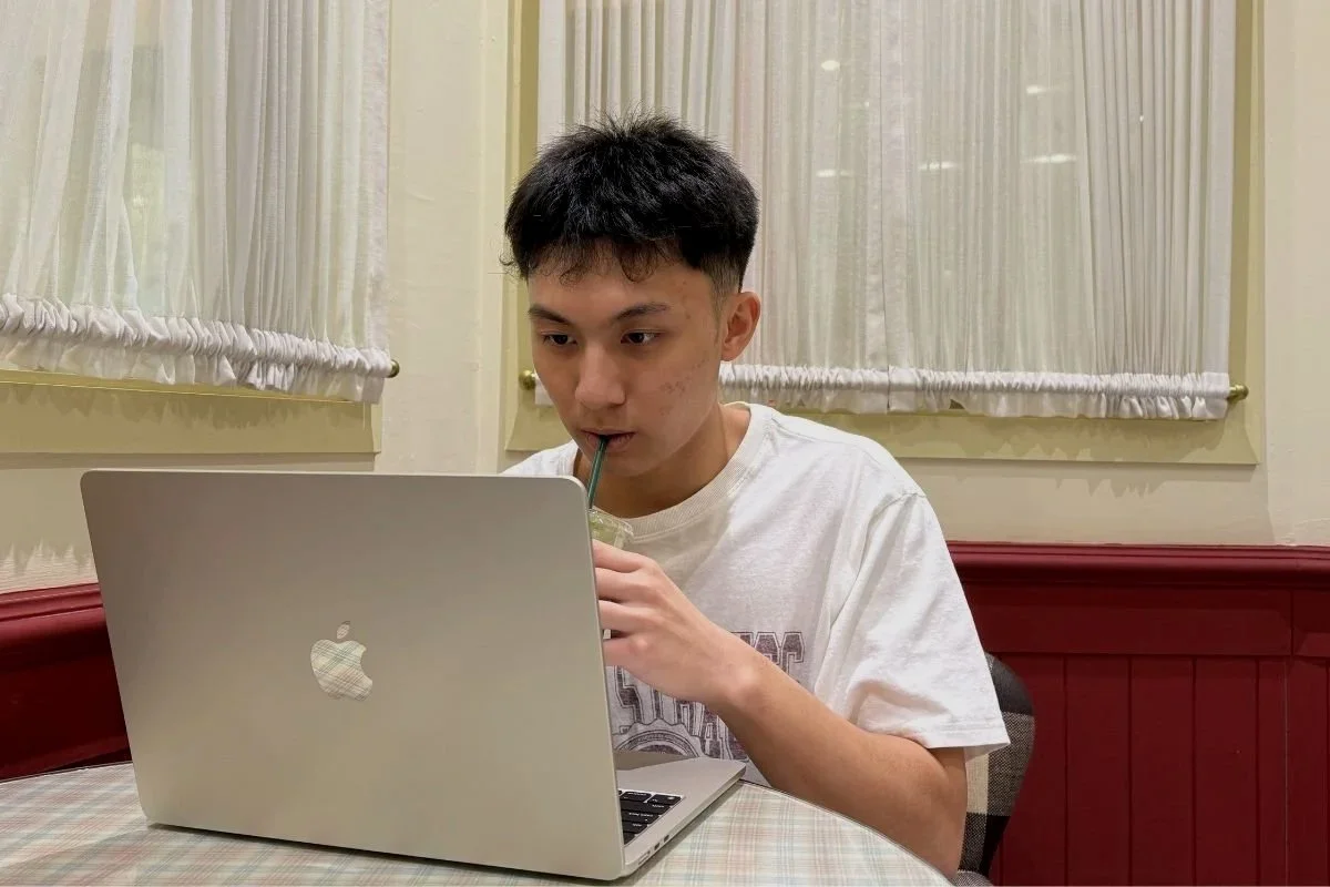 Student attending an online Mandarin class on a laptop while drinking Matcha