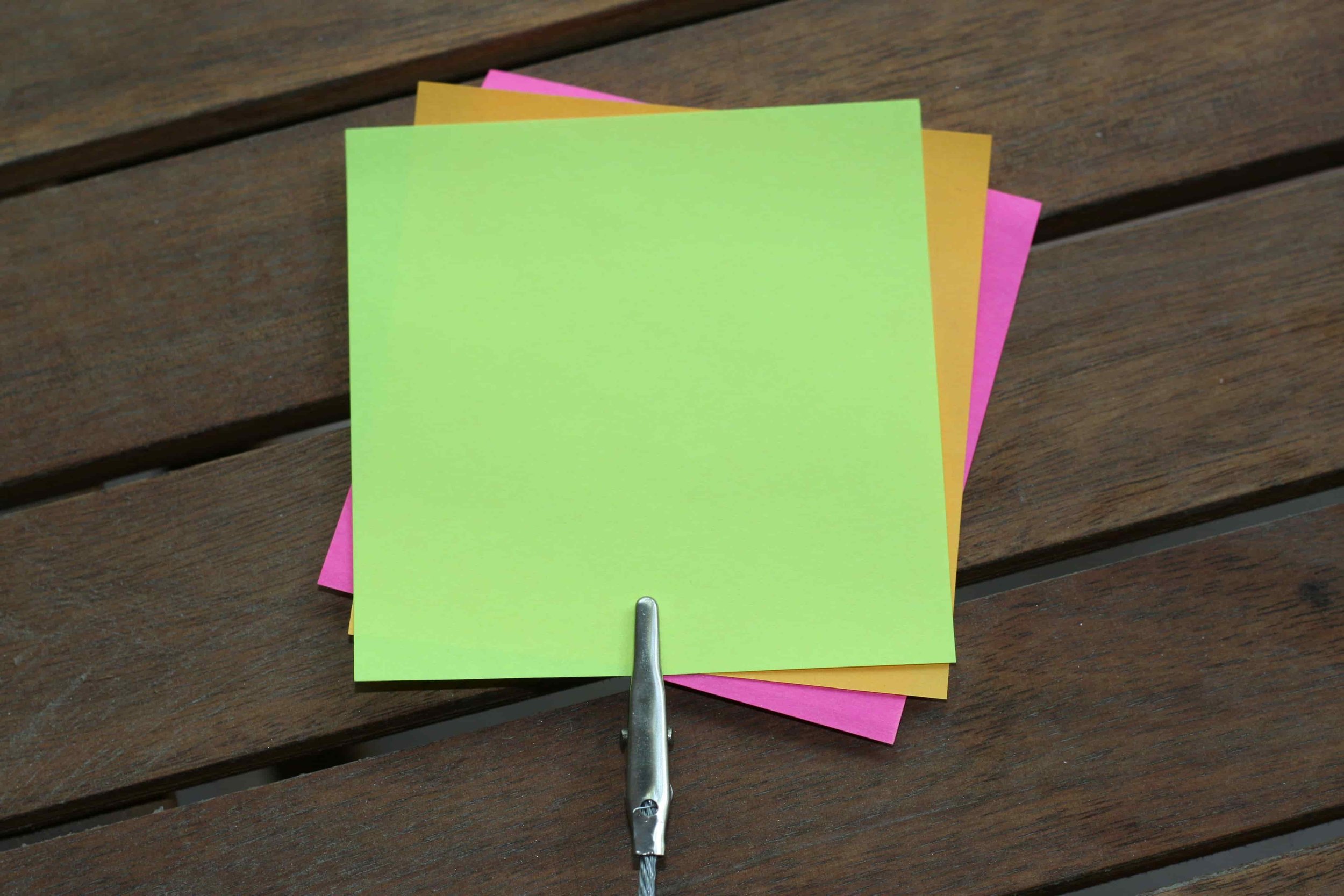 Colorful sticky notes with a clipped on a wooden table