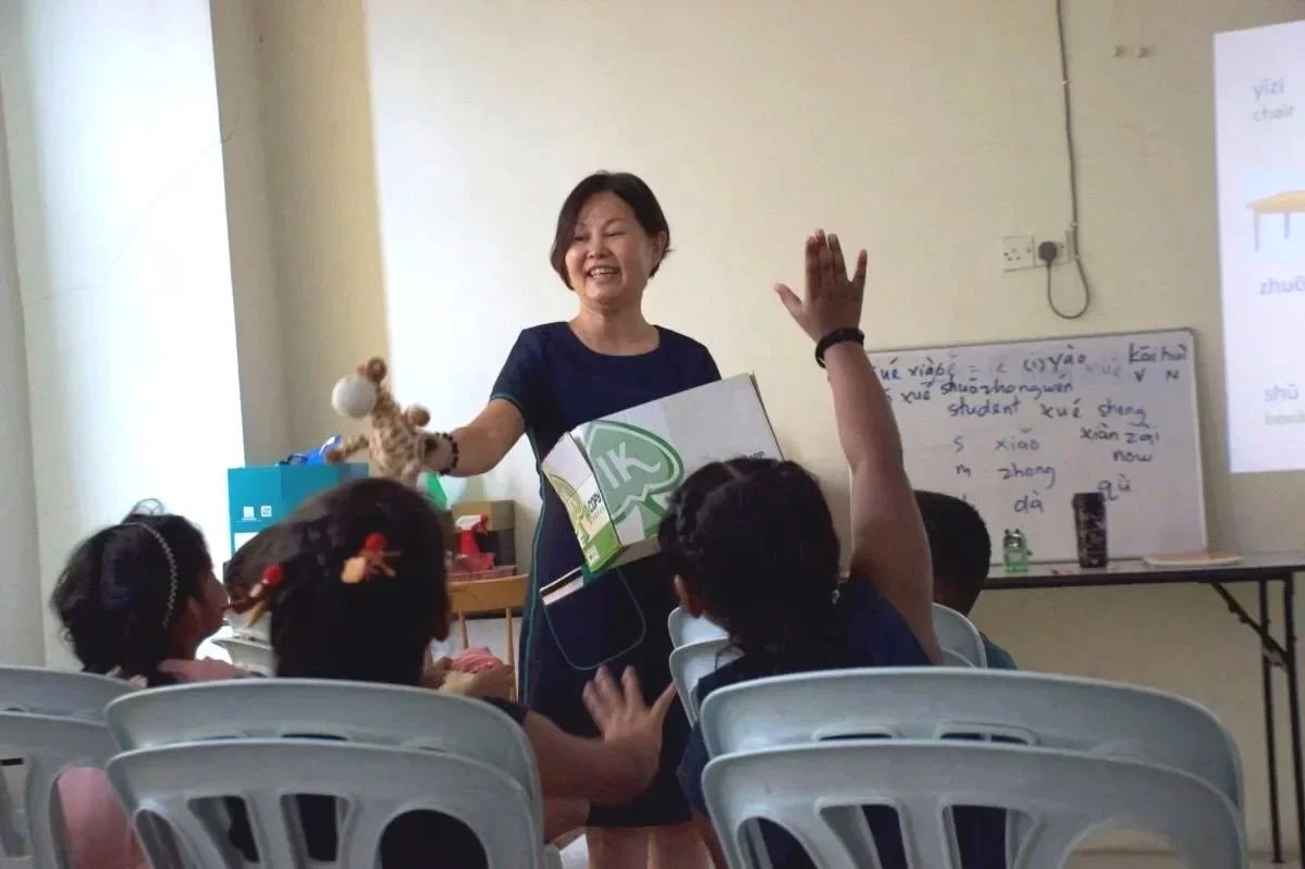 Mandarin teacher giving toys to children during a Mandarin lesson in Banting