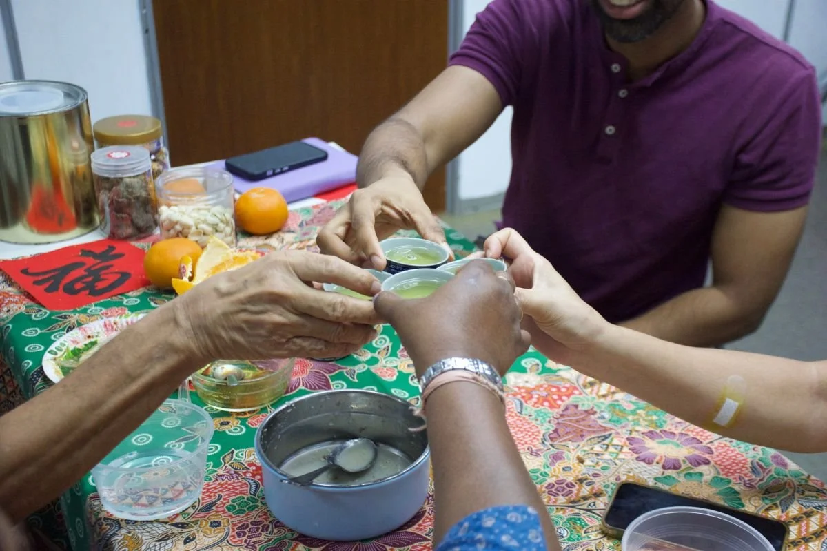 Students and teacher clink their cup of tea celebrating Chinese New Year