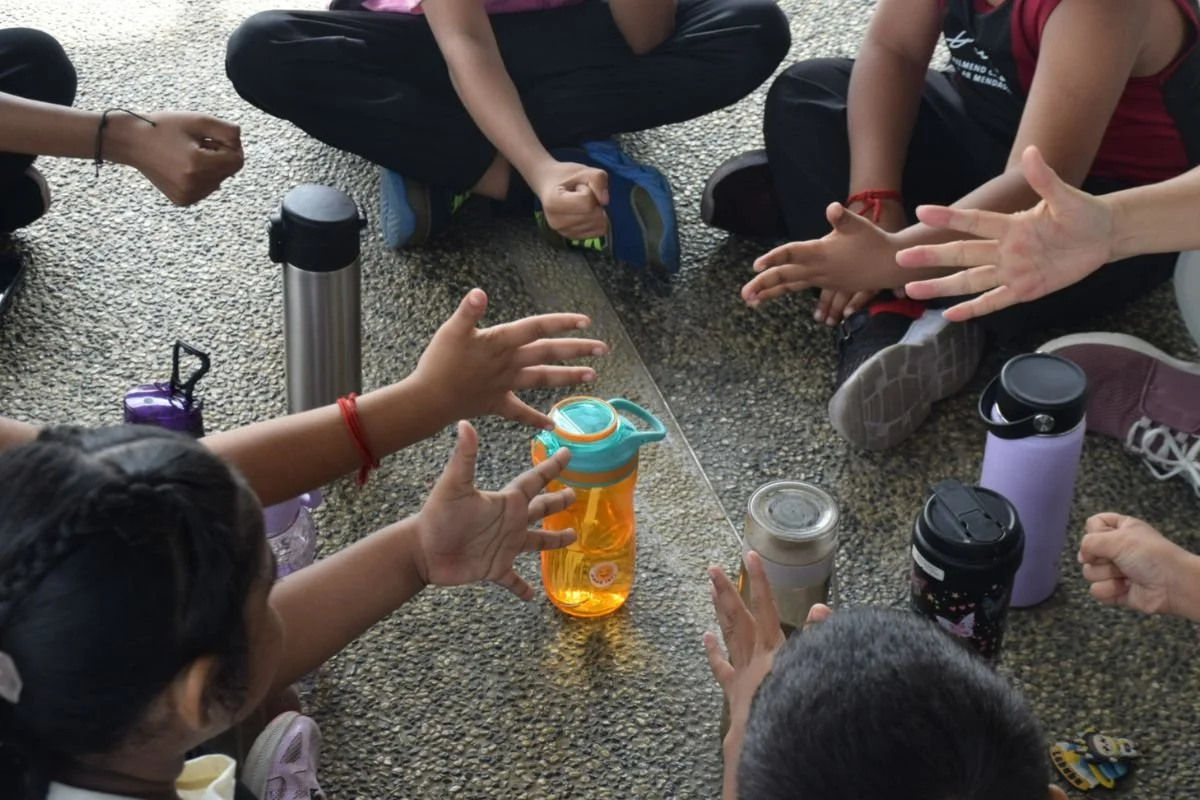 Children playing with their hands during an outdoor Mandarin class in Banting, Selangor