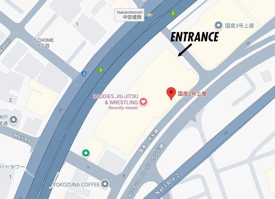 地図上の施設と道路、建物の配置を示す白地図。入口を示す矢印と「ENTRANCE」という文字。赤いピンで「国産2号上屋」と表示された位置。施設名「BADDIES JIU-JITSU & WRESTLING」が中心に配置されている。