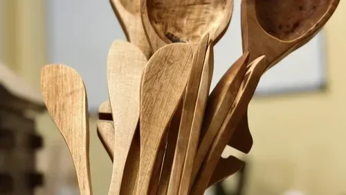 A collection of wooden cooking spoons and spatulas standing upright.