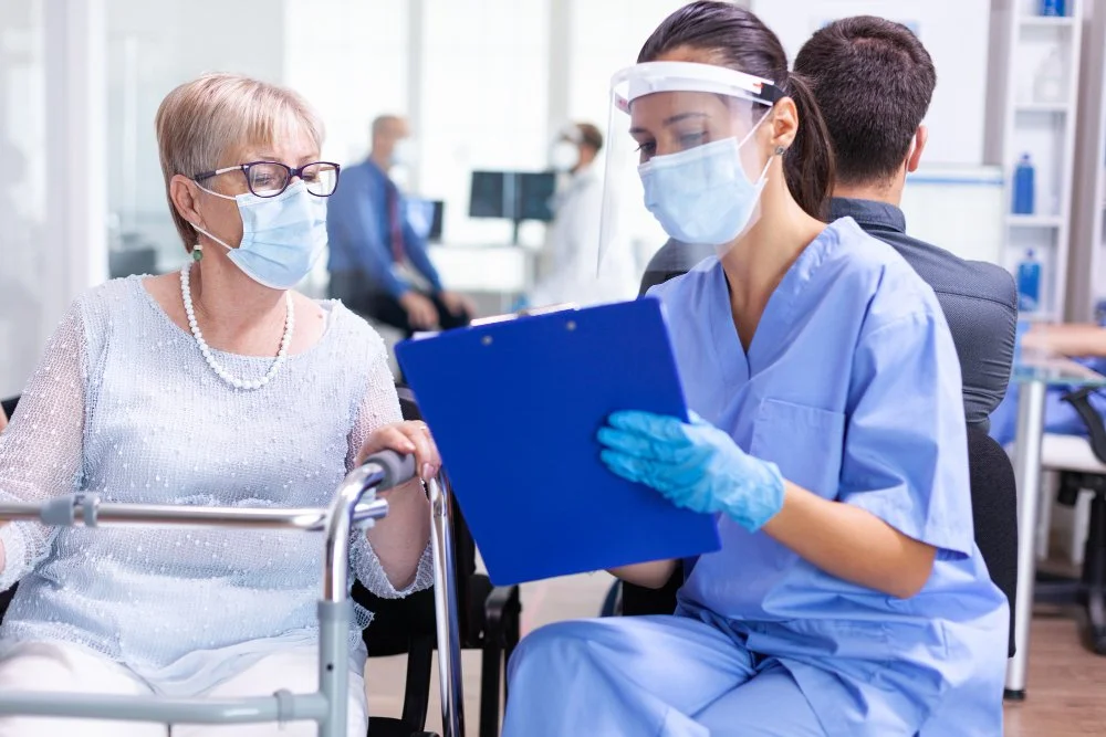 Healthcare worker with mask and gloves taking patient information
