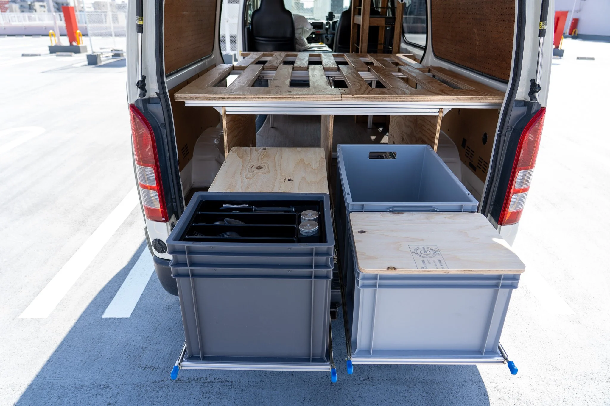 荷台に木製の棚とプラスチックコンテナが載っている車の後ろ側の写真