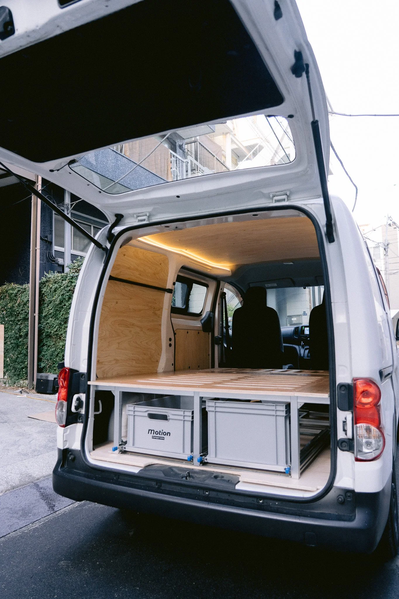 バンの荷台内部、木材と収納棚、コンテナが設置されている光景