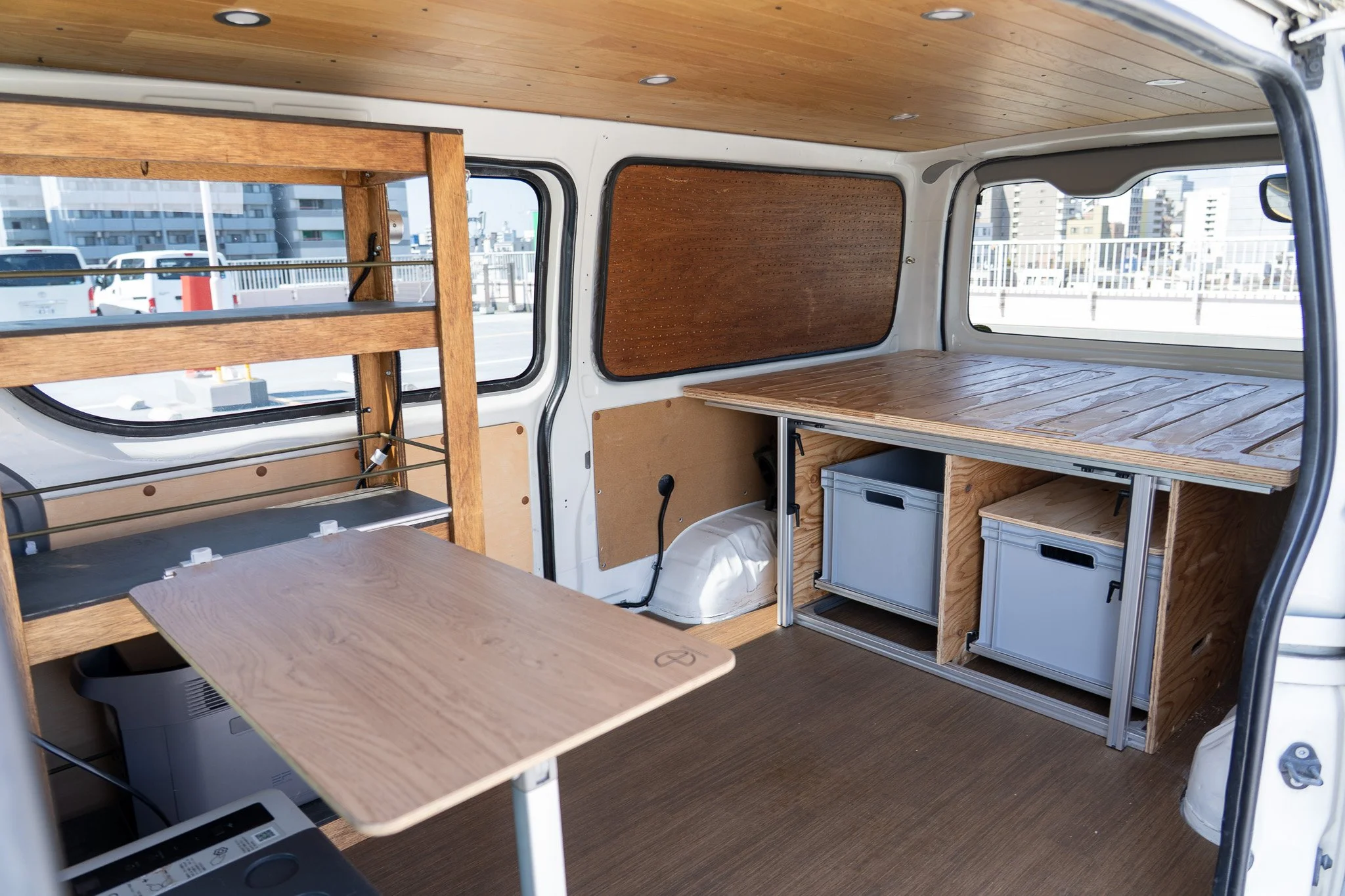 車の中に木製の棚と机が設置されているキャンピングカーの内装