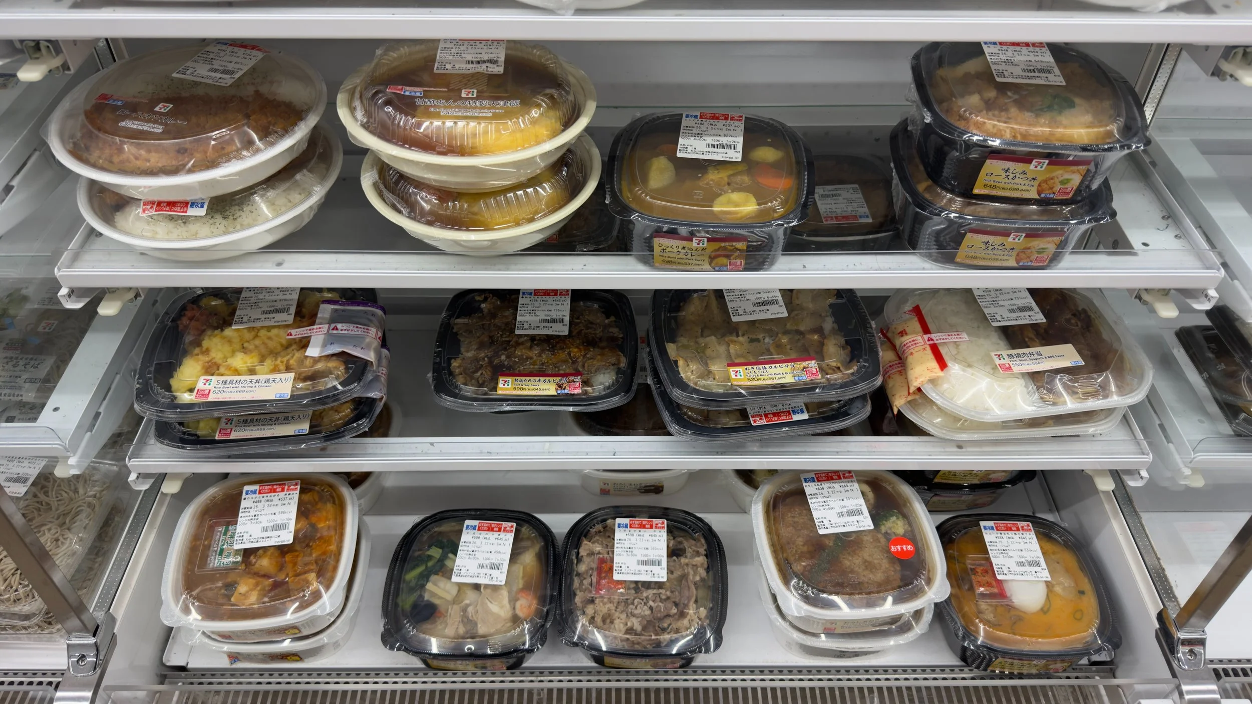 Shelf of ready-made convenience store meals in Japan with English labels