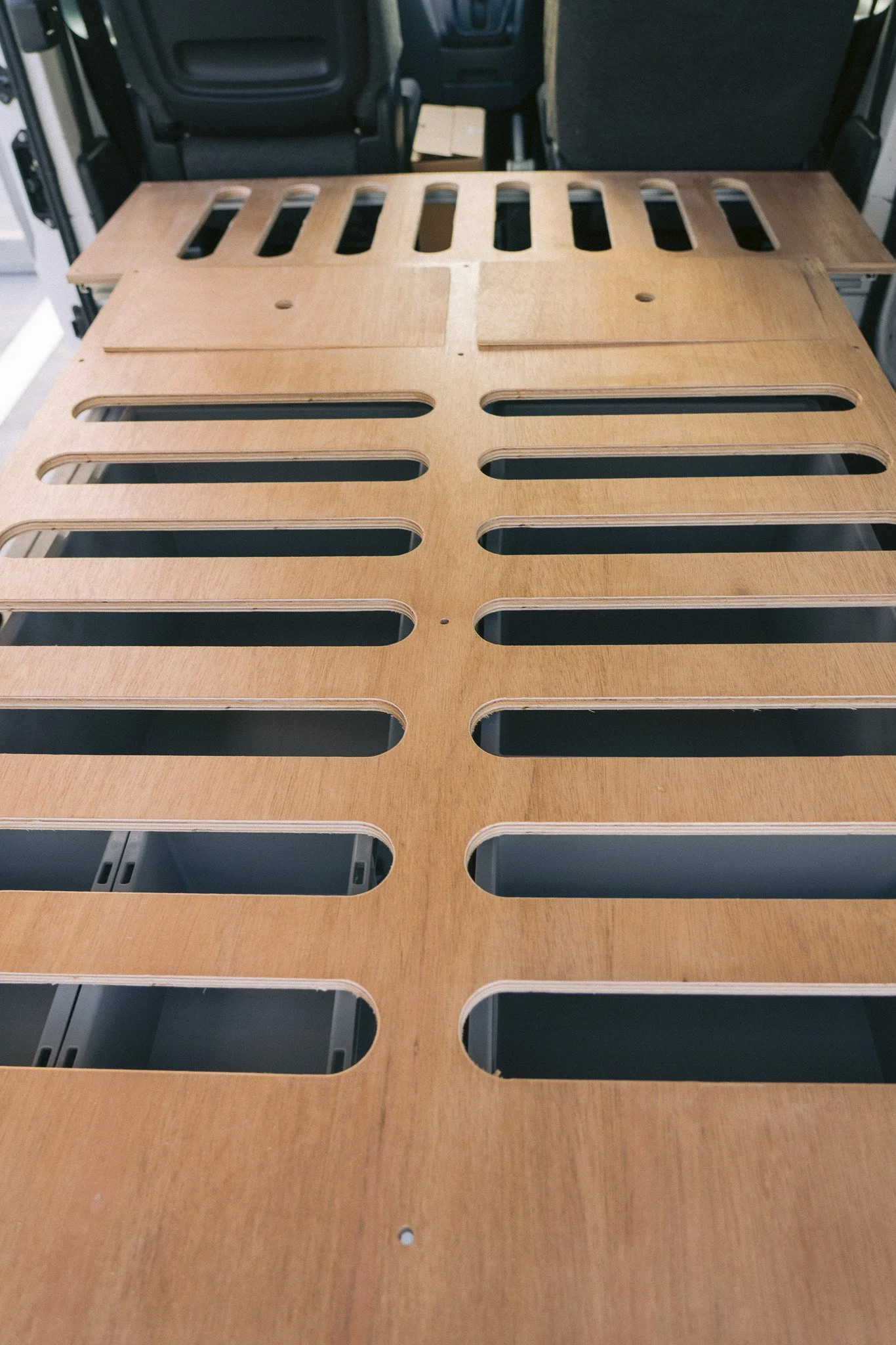 A flat and sturdy wooden bed platform designed for comfort, ventilation, and a good night’s sleep on the road.