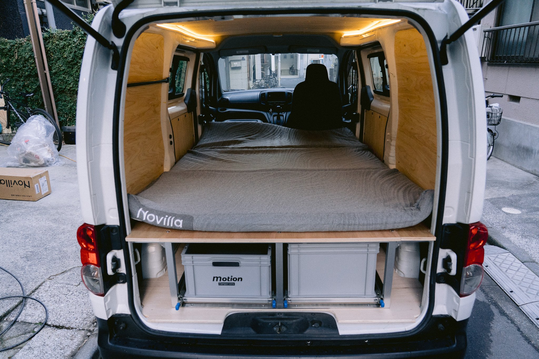 Campervan interior with bed and storage shelves in Japan