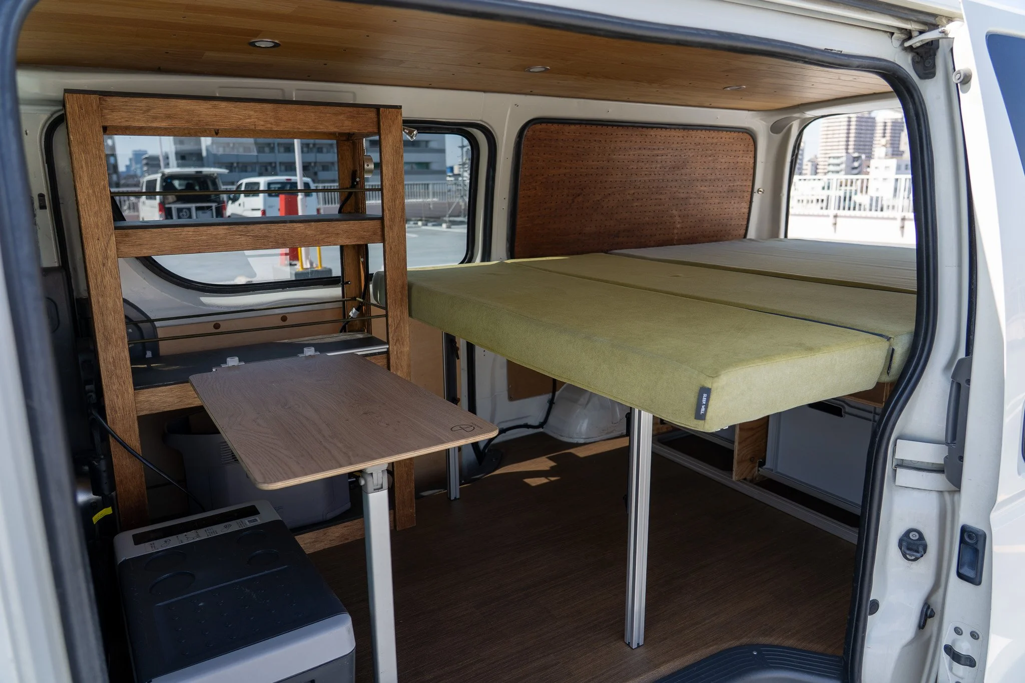 キャンピングカーの内部、寝床とテーブルが設置されている