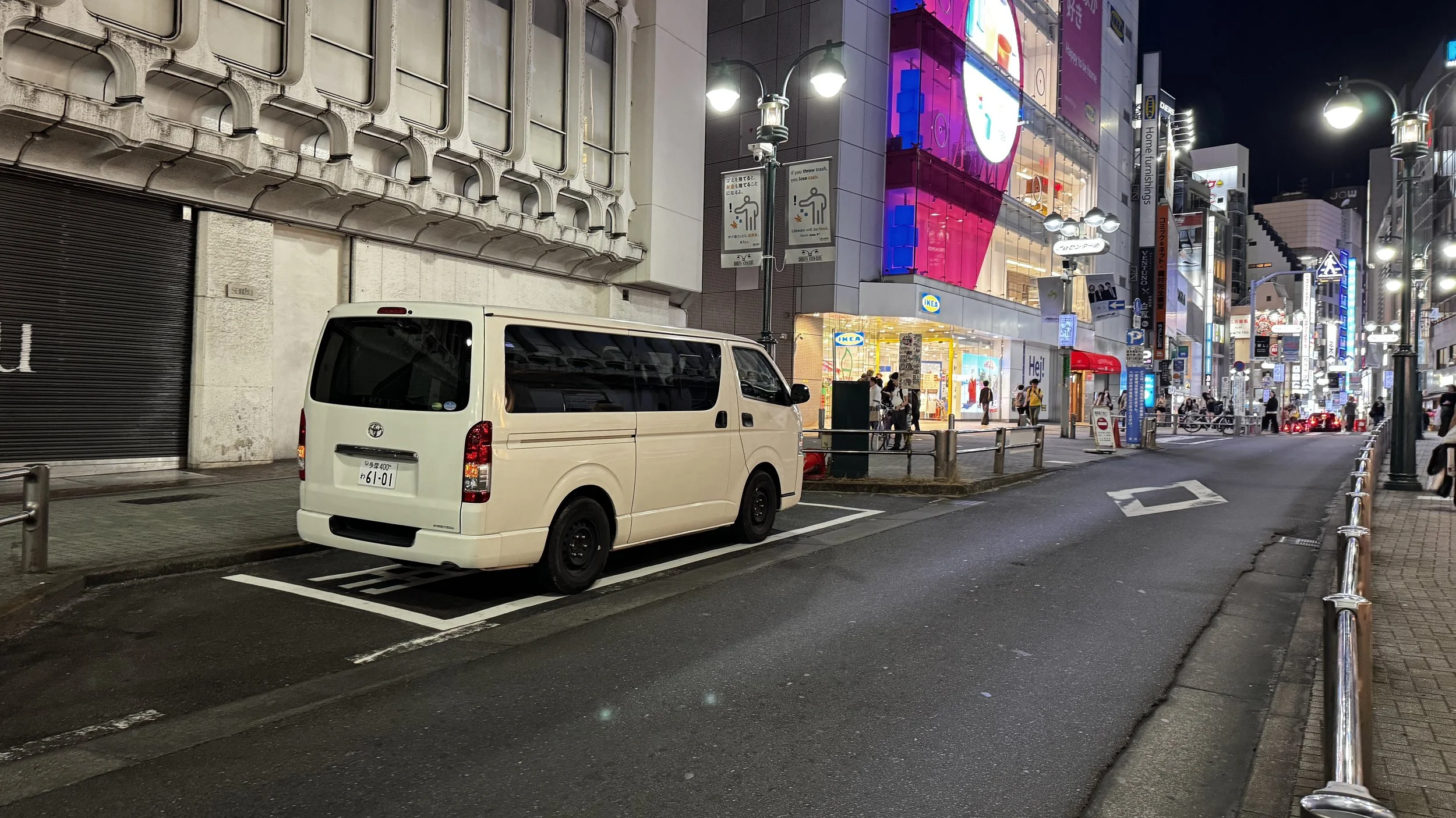 Shibuya nightlife district with campervan parked near IKEA storefront at night
