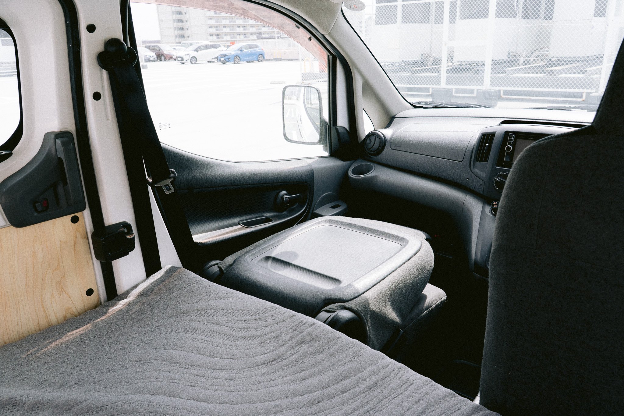 荷物を載せるためのテーブルがついたバンの車内の座席と運転席の様子