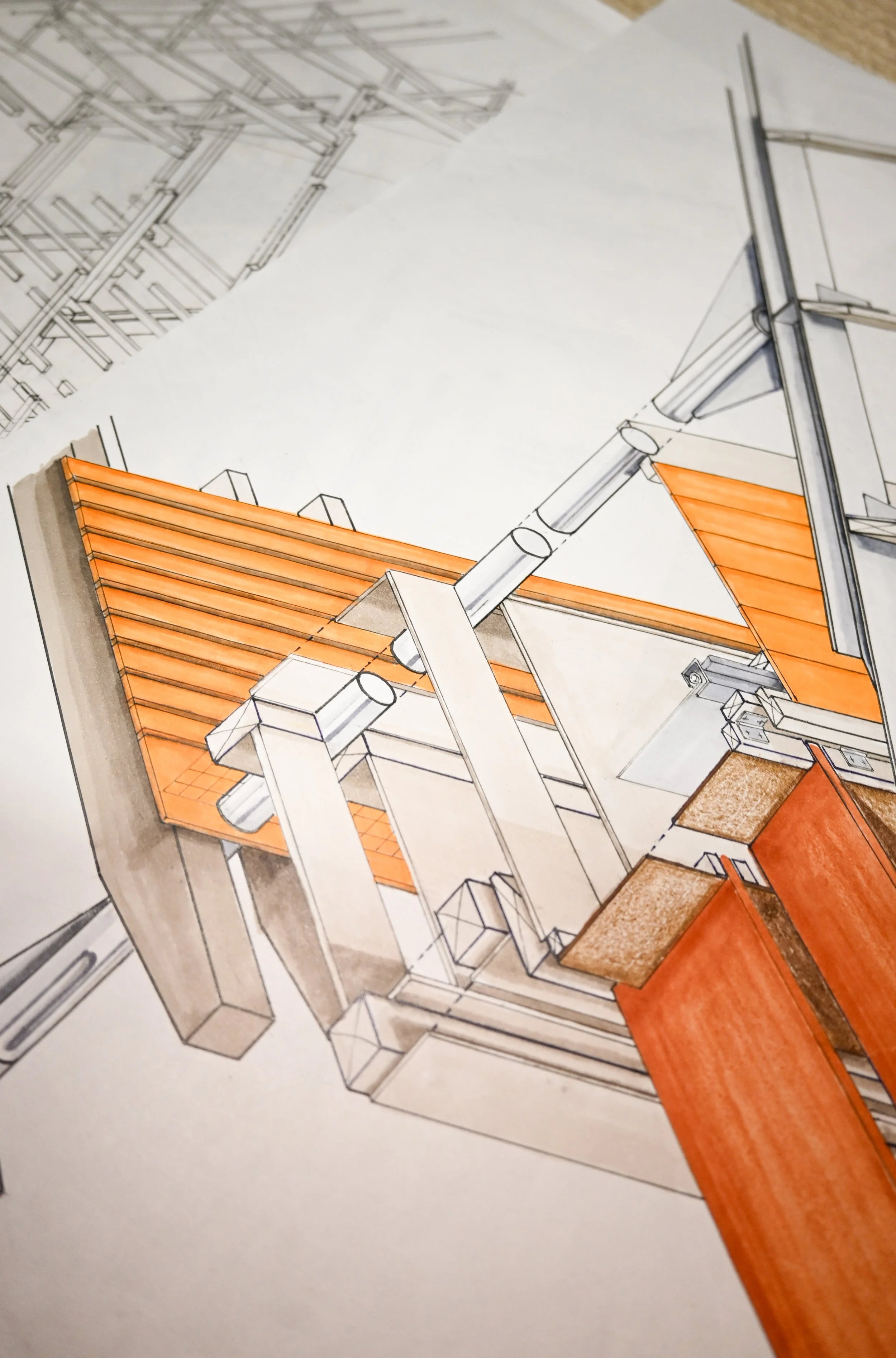 Architectural drawing of a building with some parts colored in orange, including a roof with tiles. The drawing is on paper with other sketches and blueprints visible in the background.