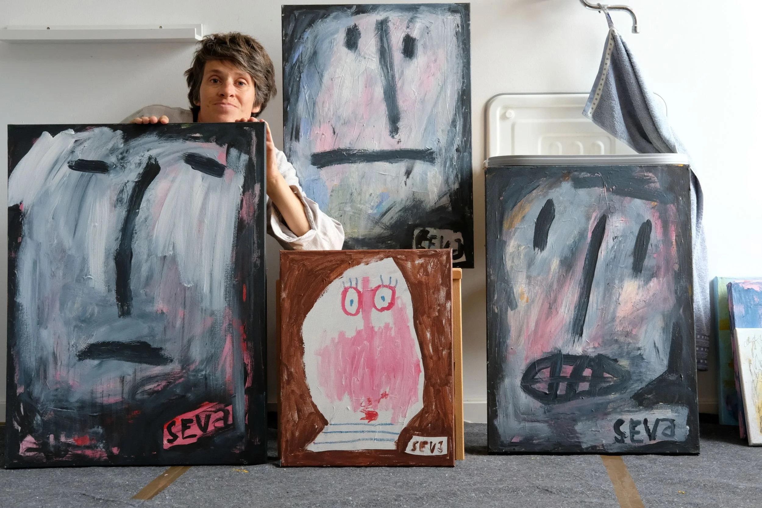 Lenka Seva mit ihren Kunstwerken „Zweifel“, „Das Unbekannte“, „Drama“ und „Ungenügend“ im Atelier.