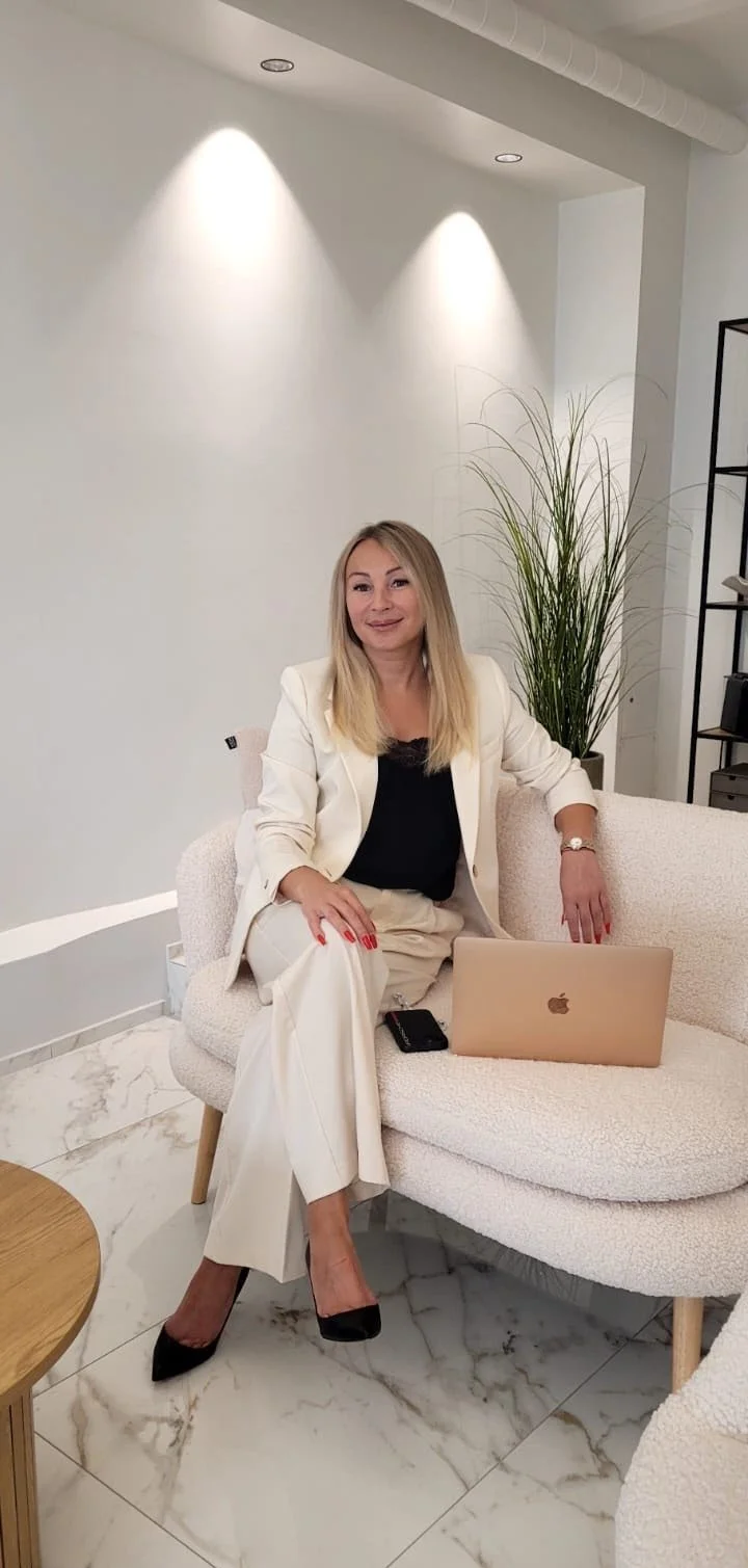 Darja istumassa rennosti pienellä vaalealla sohvalla edessään tietokone ja kännykkä