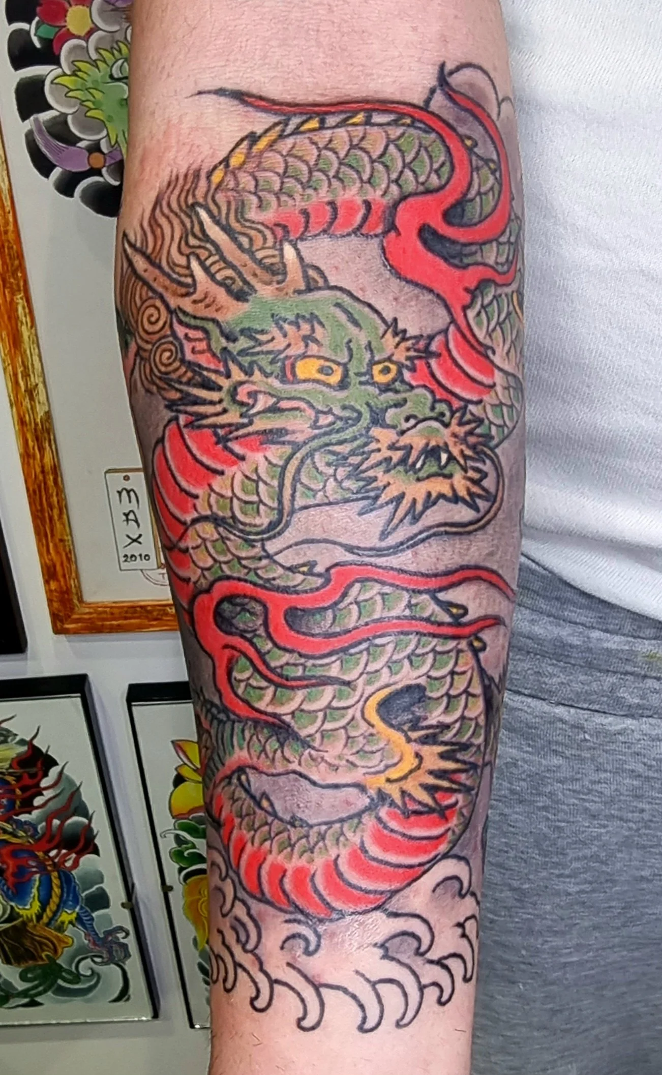 Tattoo of a colorful Chinese dragon with intricate details on a person's arm.