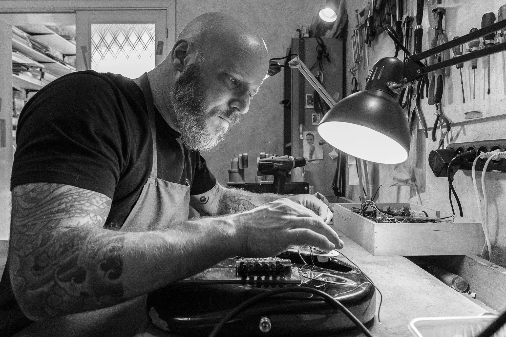 luthier jan rammeloo werkt aan een elektrische gitaar in zijn atelier in deurne