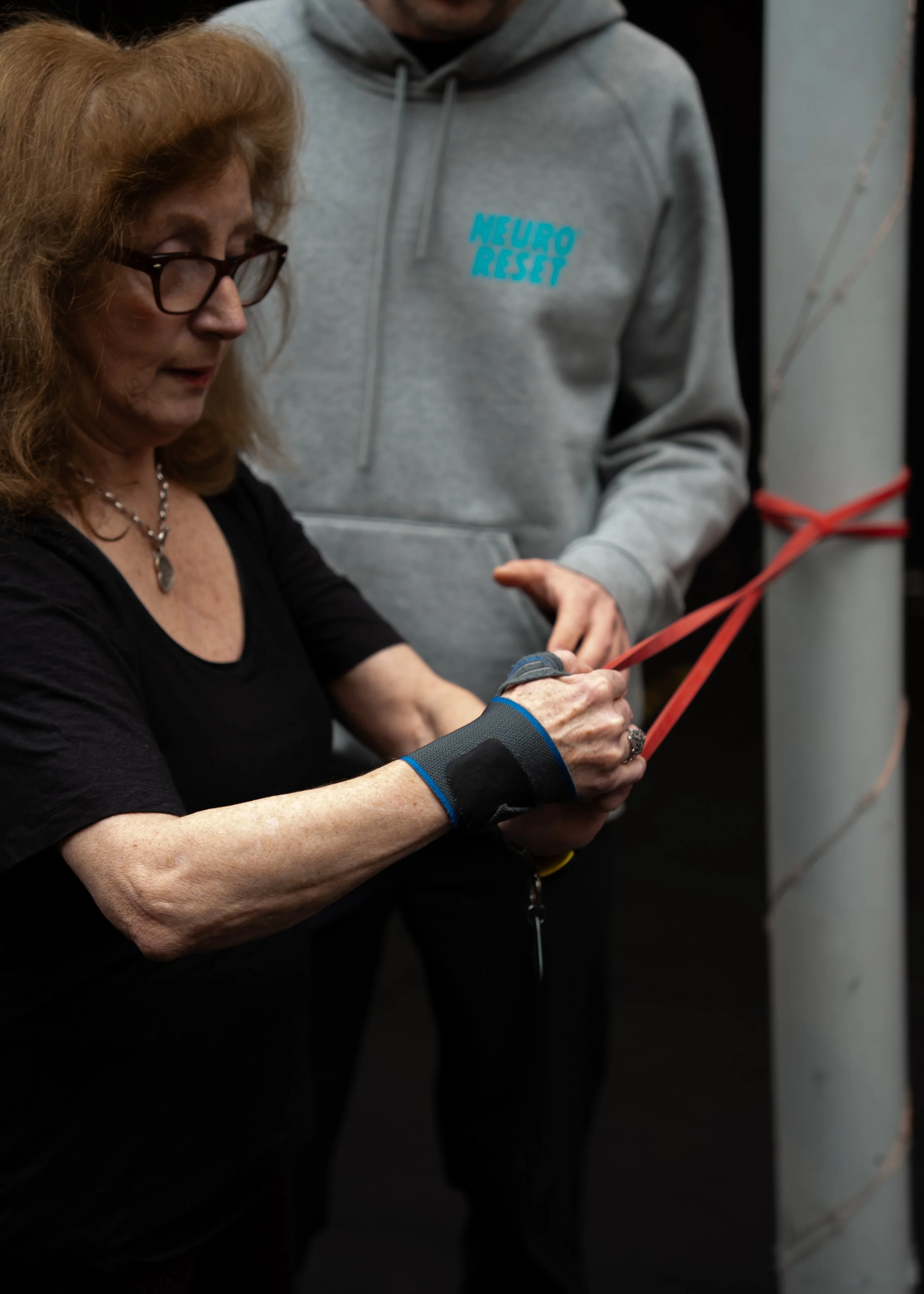 Patiënt doet schouderoefening met dynaband bij Neuroreset Fysiotherapie Heemstede