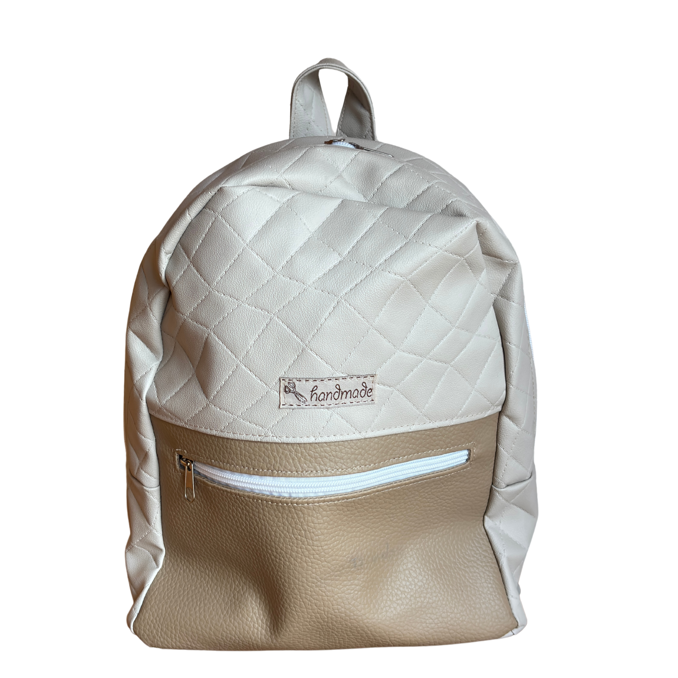 Ein beiger Rucksack mit Quiltmuster und einem kleinen Etikett mit der Aufschrift 'handmade'.